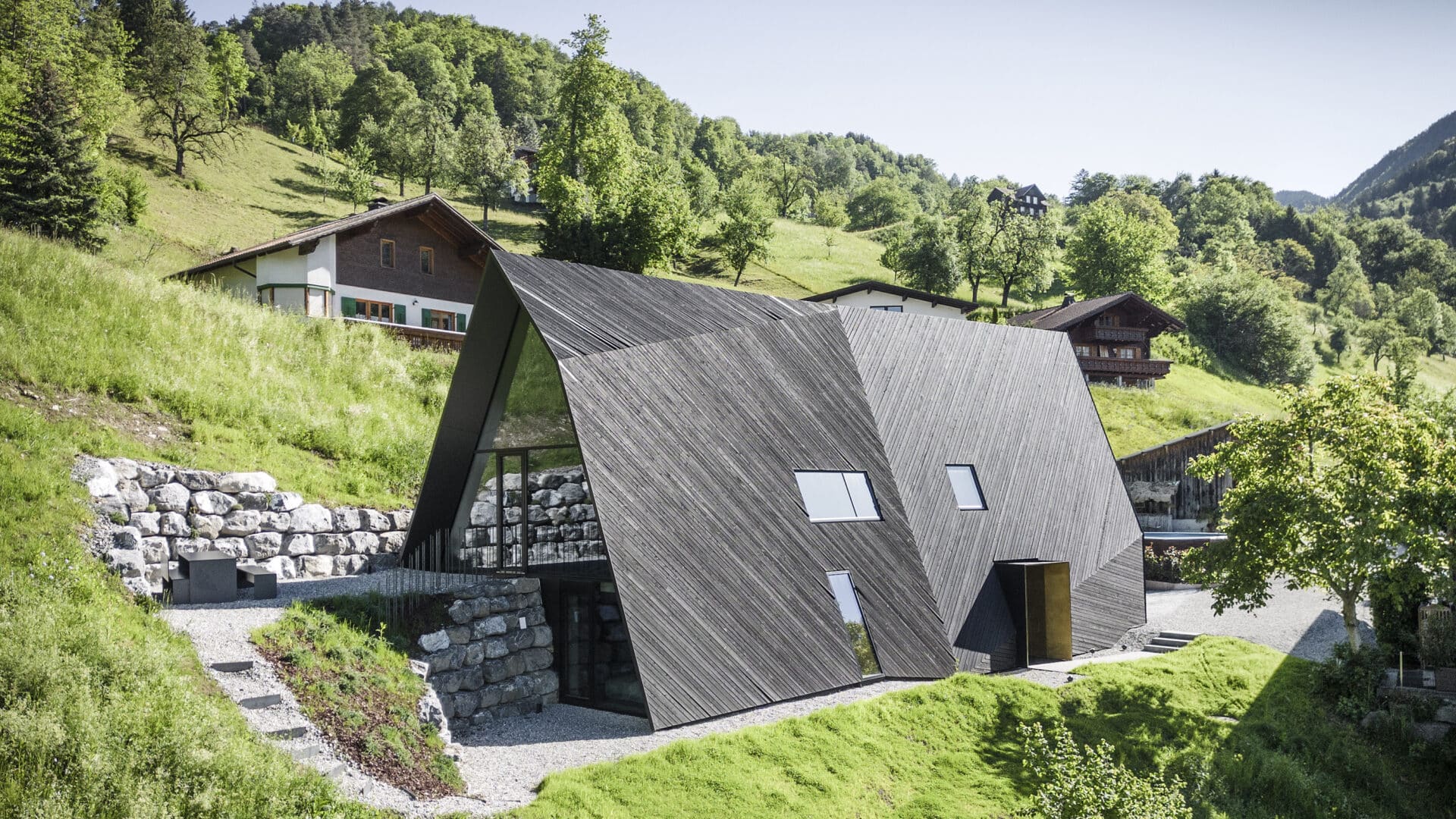 Nurdachhaus mit schwarzem Dach