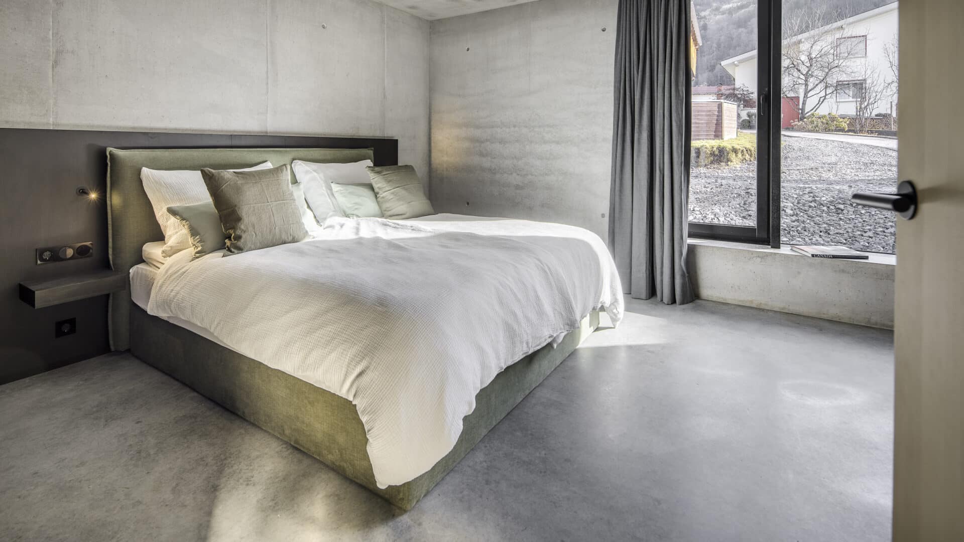 Schlafzimmer mit Doppelbett und großem Fenster