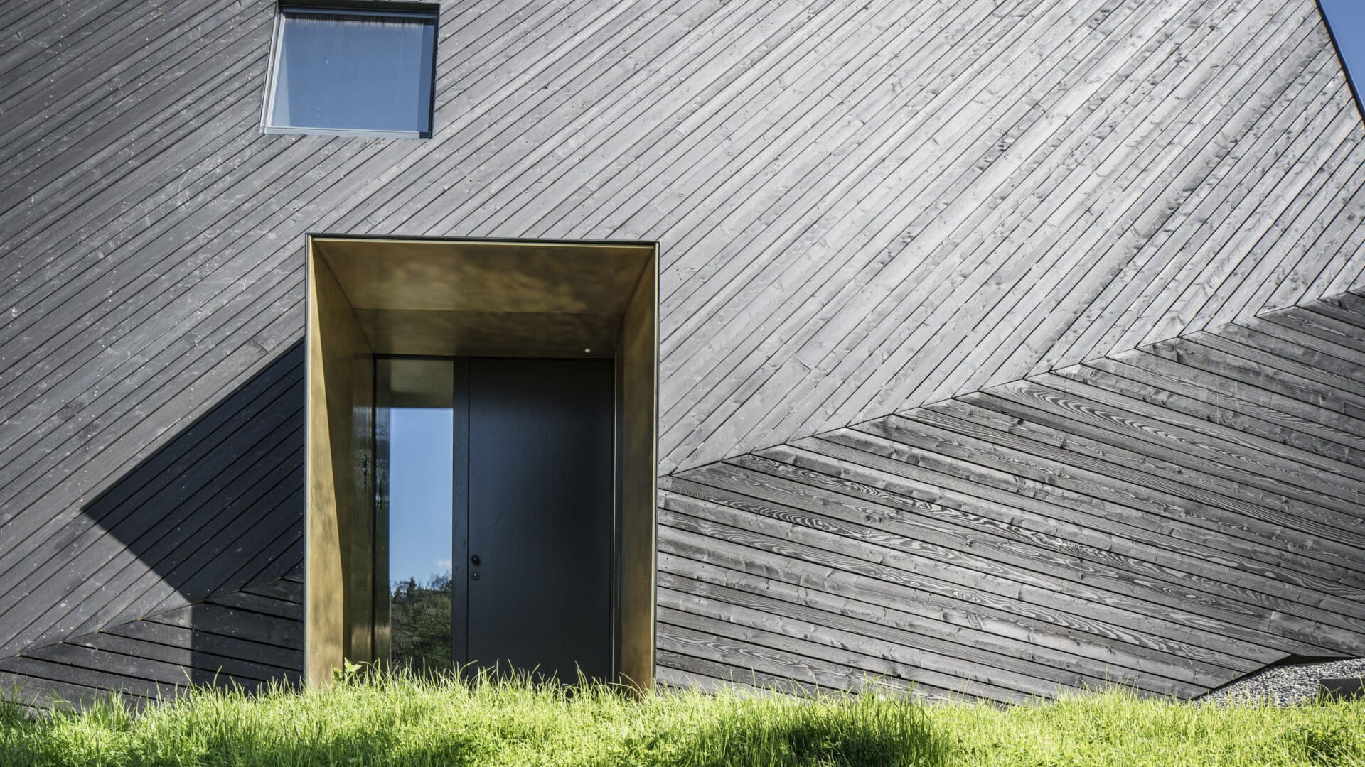 Eingangsbereich mit Hoolzfassade im Sonnenschein, VA House