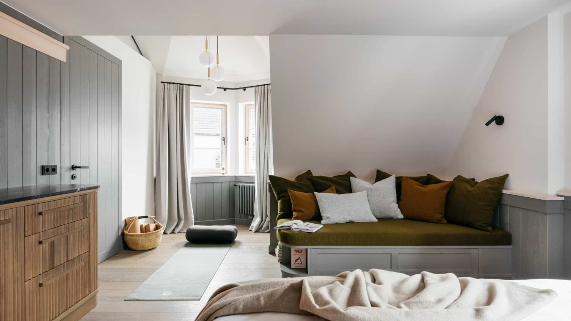 Sofaecke und ausgerollte Yogamatte im Hotelzimmer des Refugium Lunz