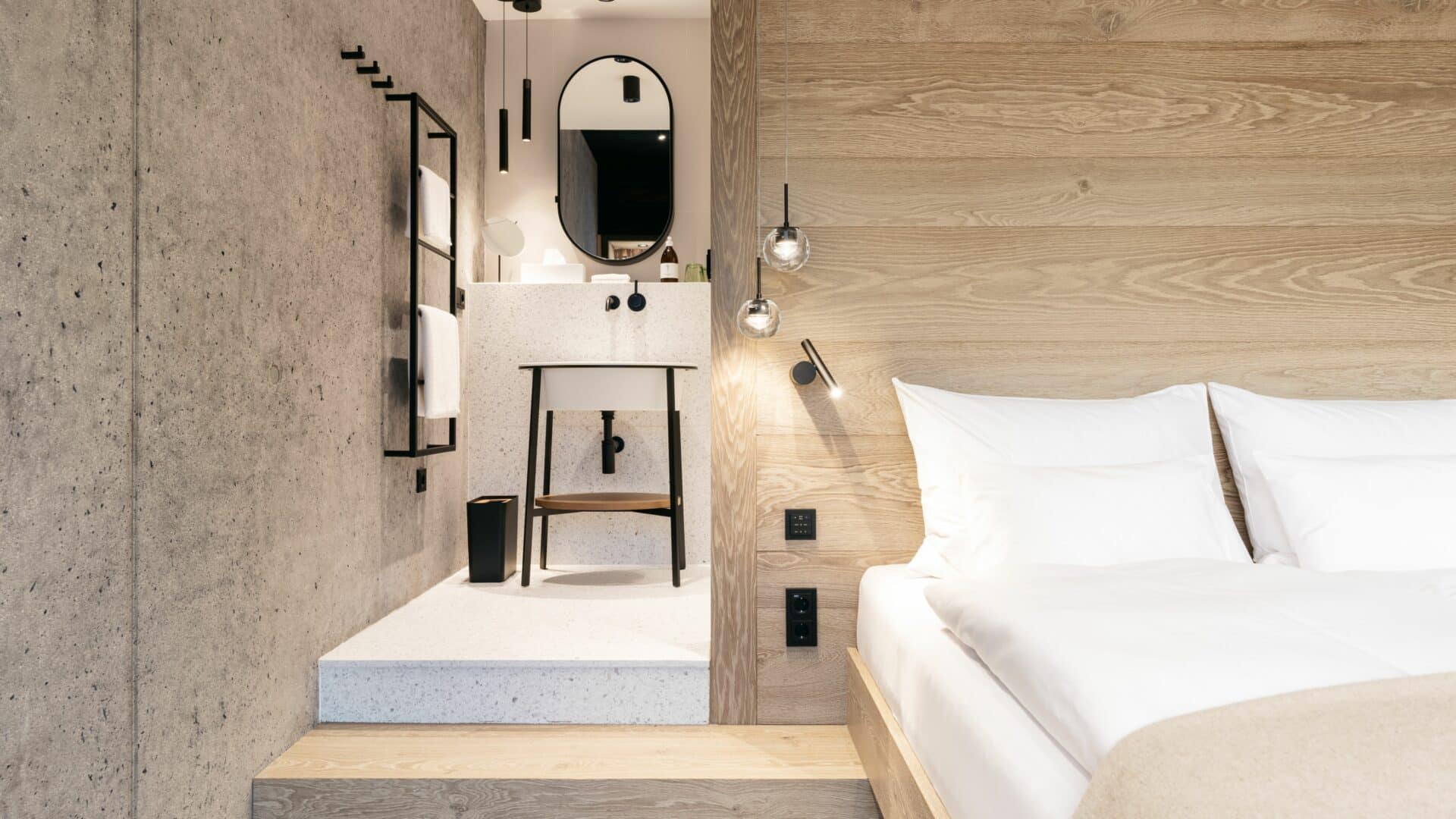Bett und Badezimmer im Doppelzimmer des Refugium Lunz