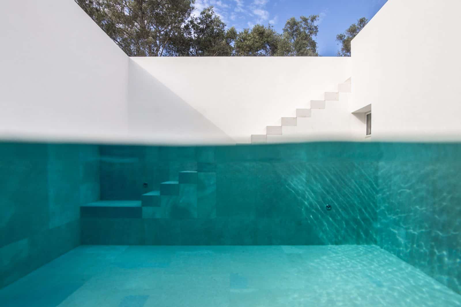 Treppe zum Pool, türkises Wasser und weiße Wände