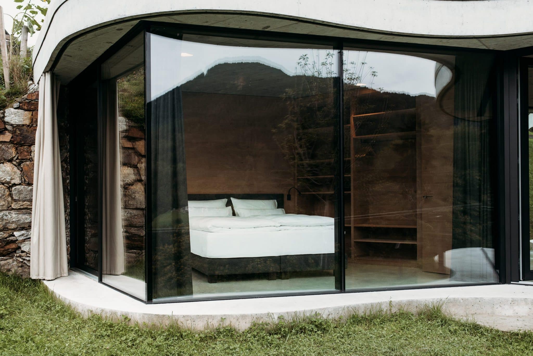 Blick von außen ins Schlafzimmer mit Bett im Gästehaus Freiform