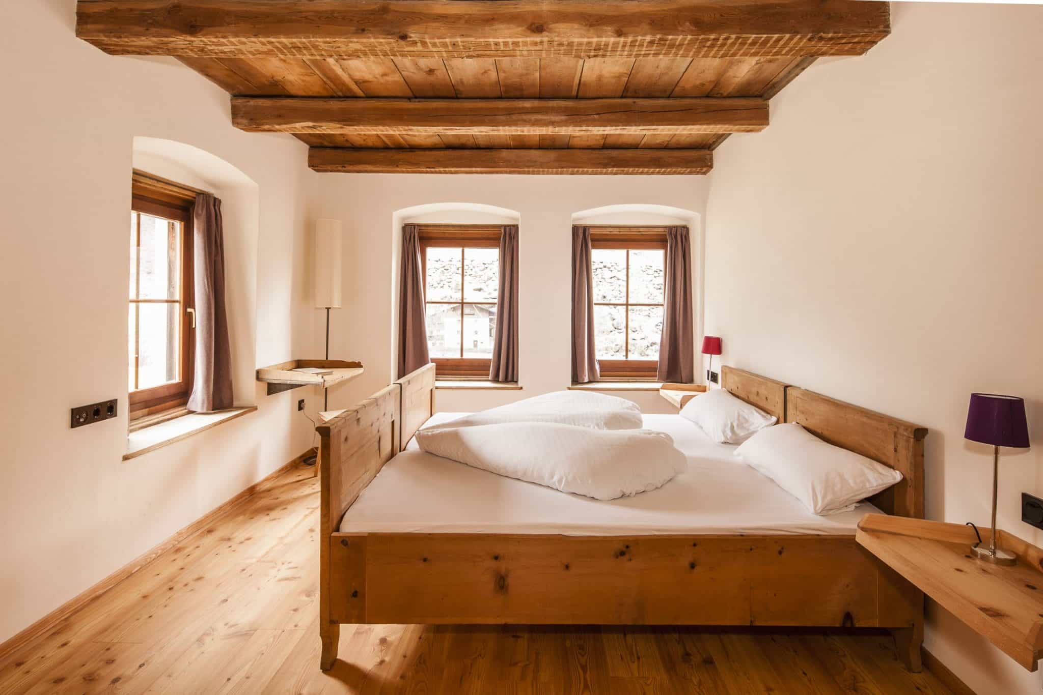 Schlafzimmer mit Bett und Decke aus Holz