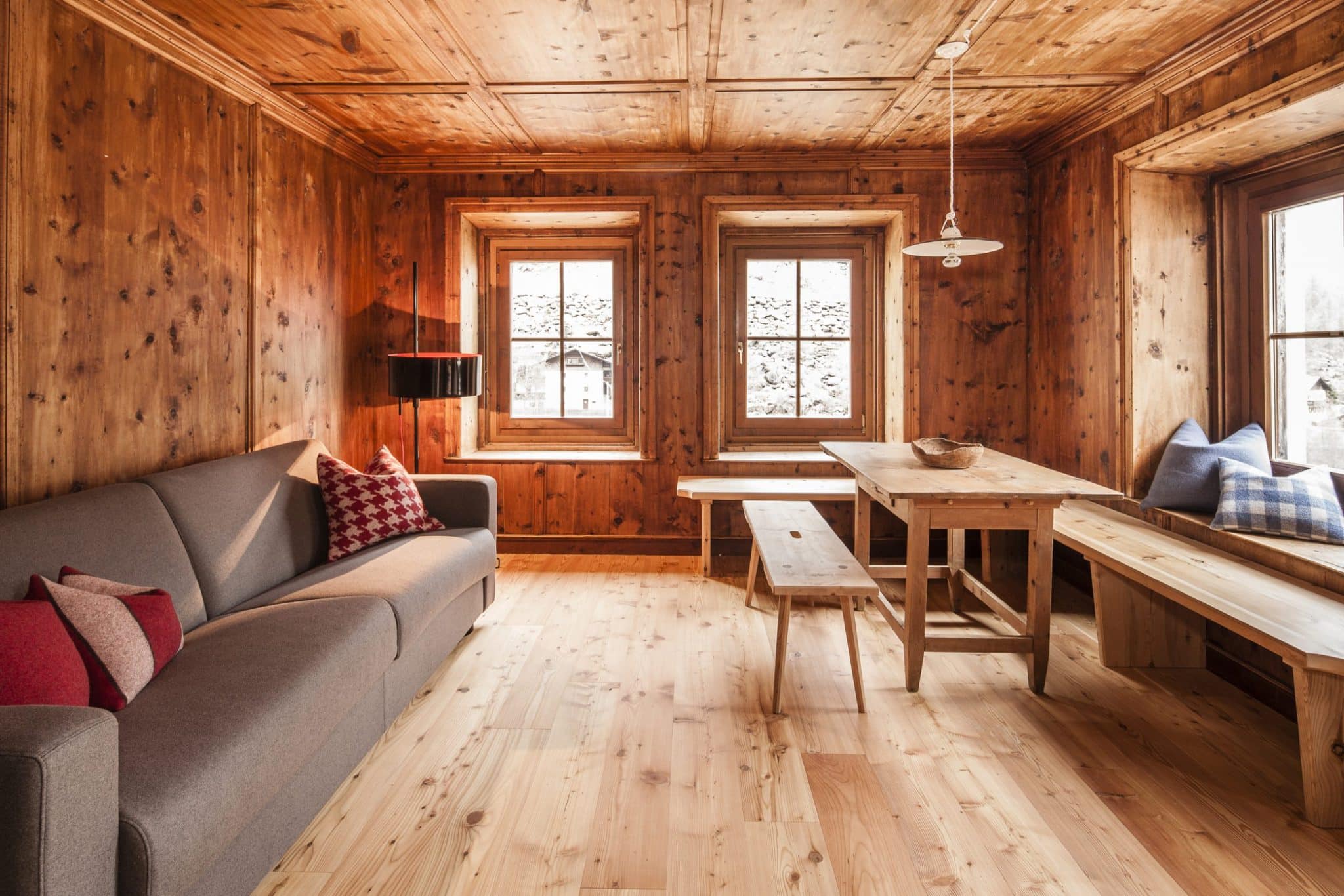 gemütliche Stube aus Holz mit Sofa und Tisch