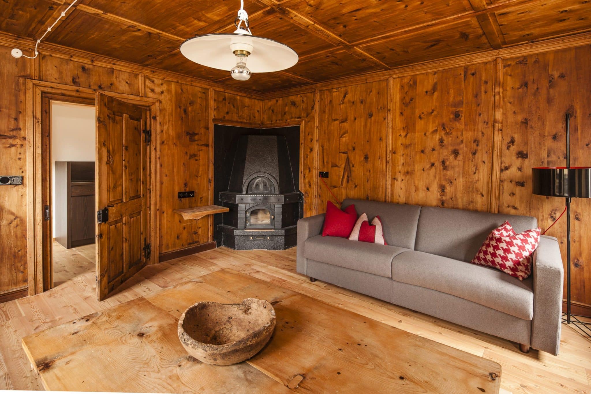 Stube aus Holz mit Sofa und Kamin