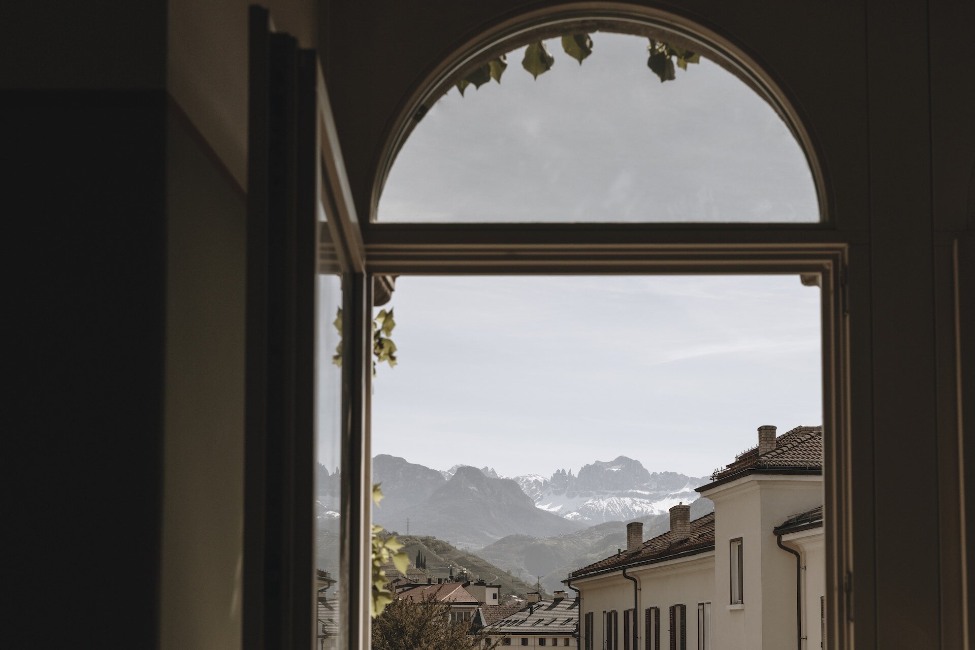 Ausblick durch ein Bogenfenster auf Bozen im Parkhotel Mondsch