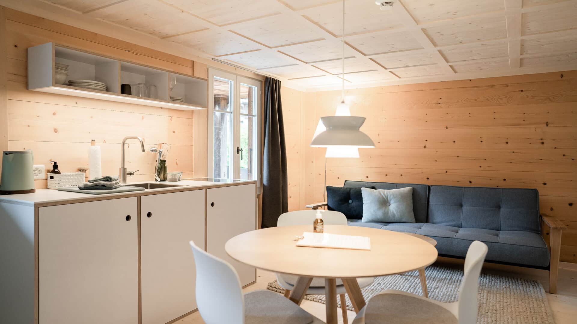 Küchenzeile mit Tisch und Sofa in der Lenk Lodge