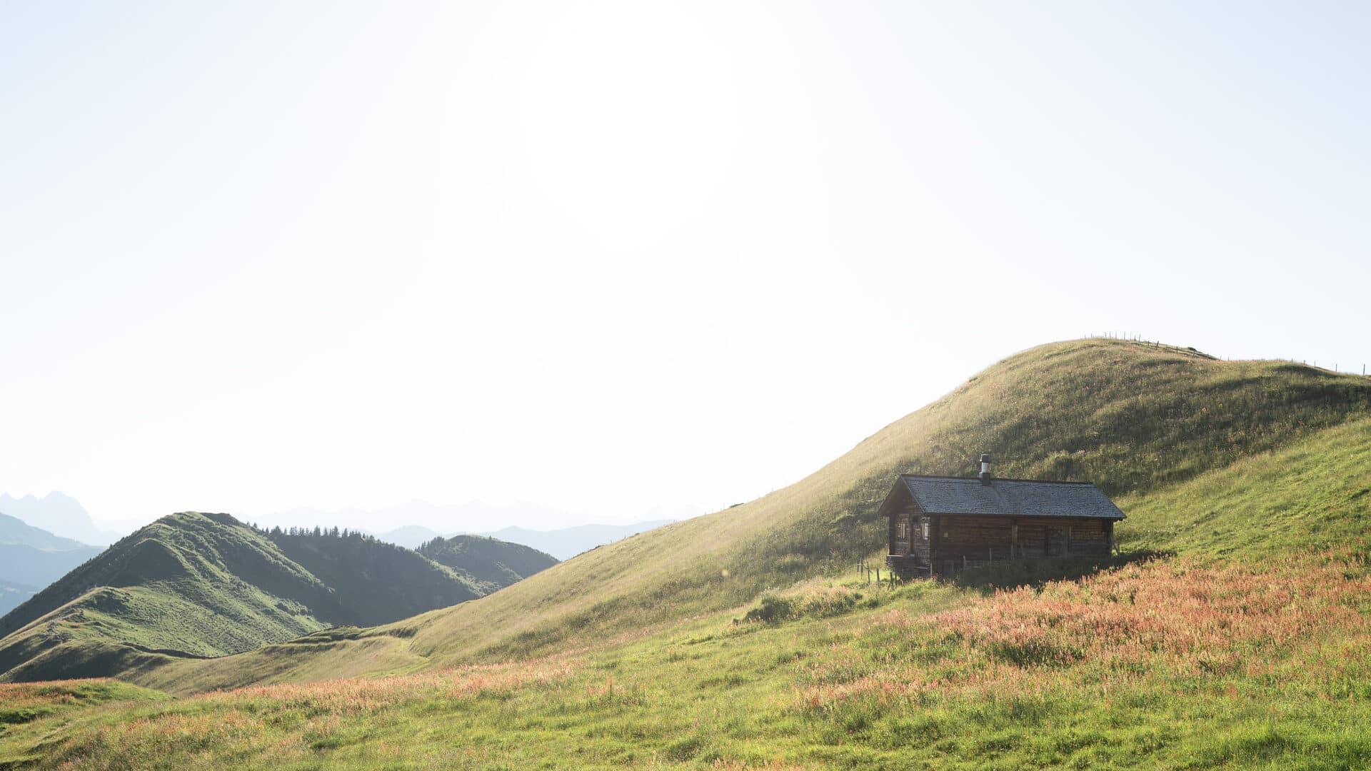 Holzhütte auf begrünten Hügeln