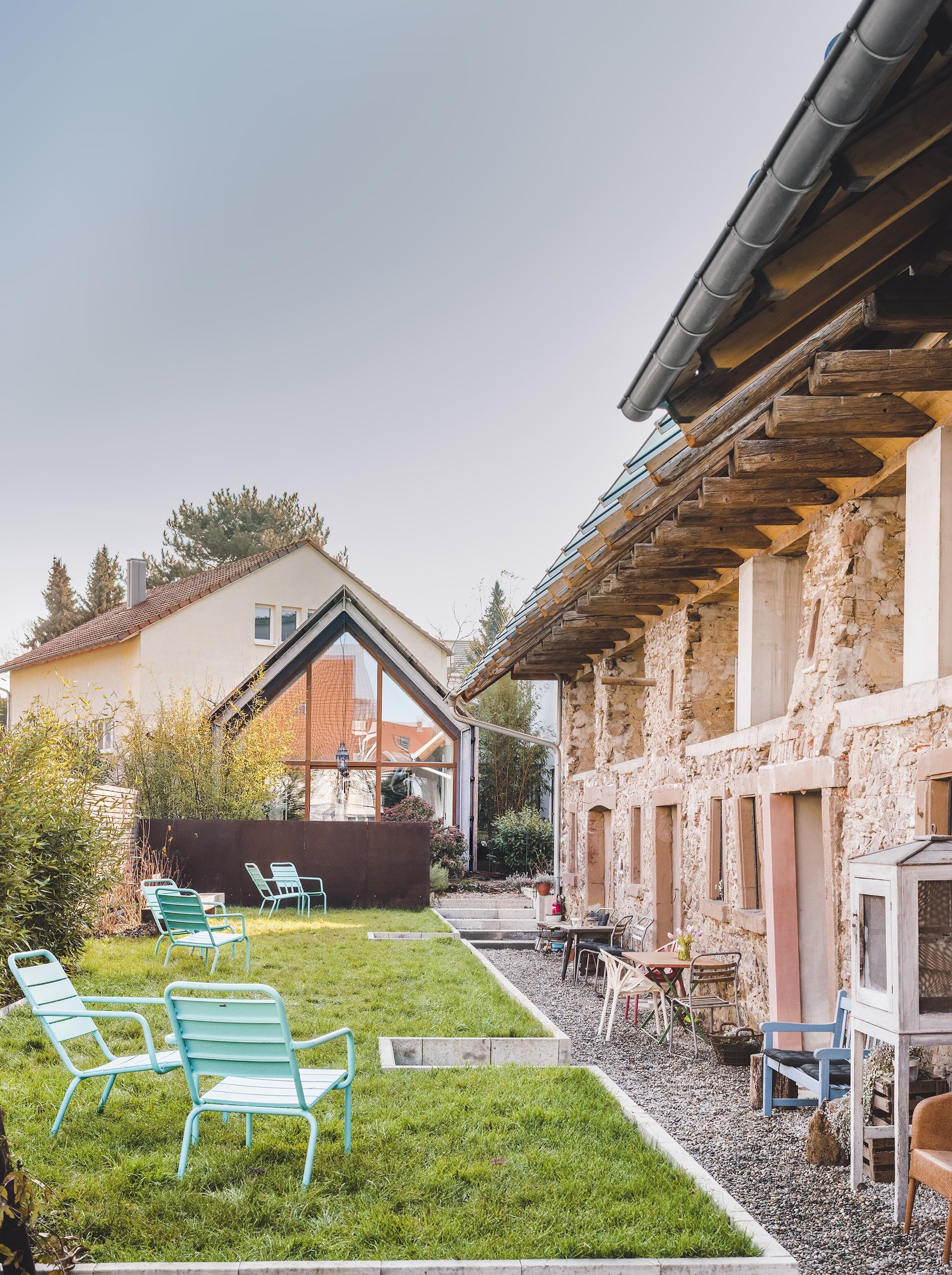 Garten mit Sitzplätzen und unverputzte Fassade des Friz BnB
