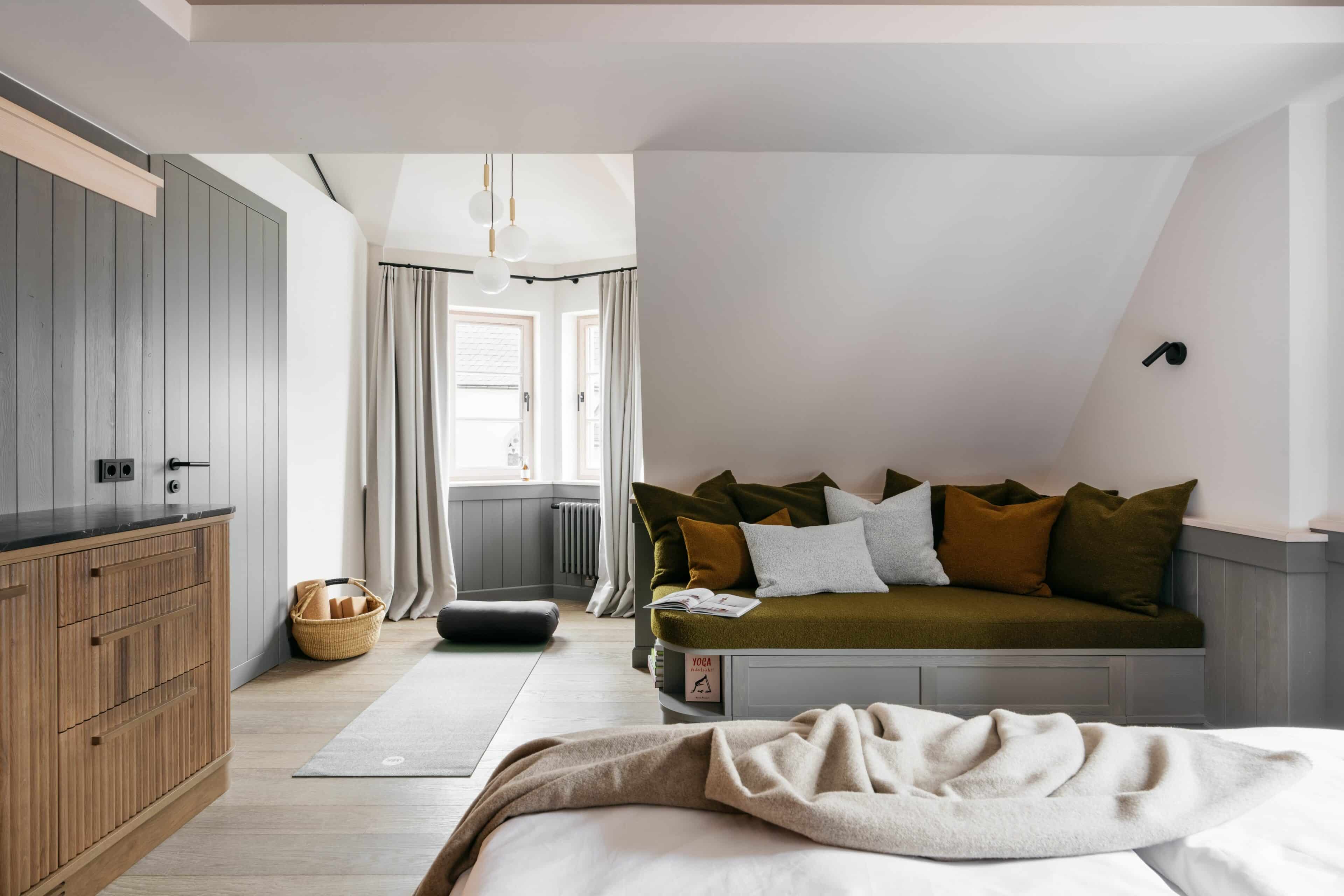 Sofaecke und ausgerollte Yogamatte im Hotelzimmer des Refugium Lunz