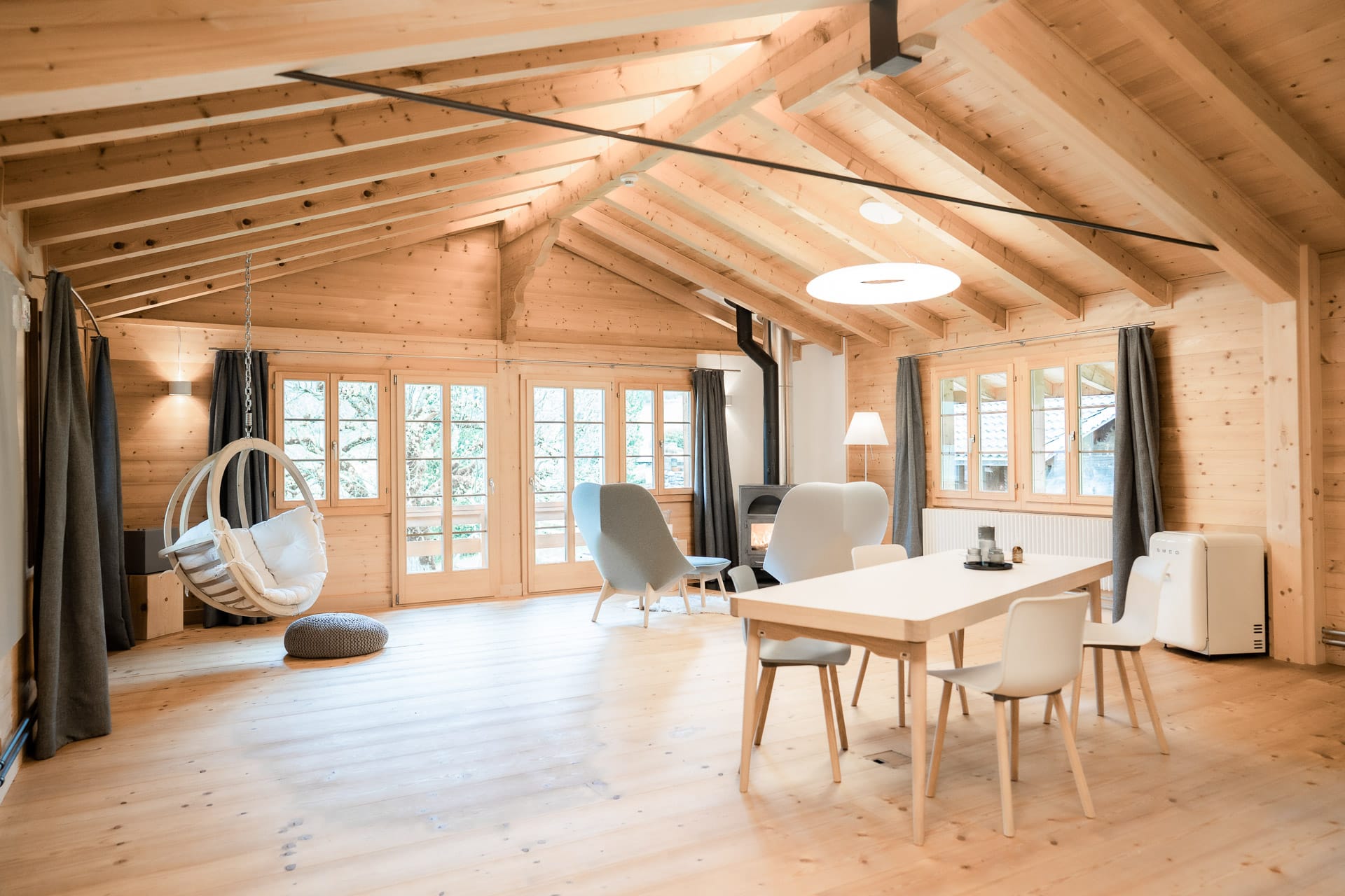 Großes Wohnzimmer mit Esstisch und Kamin in der Lenk Lodge