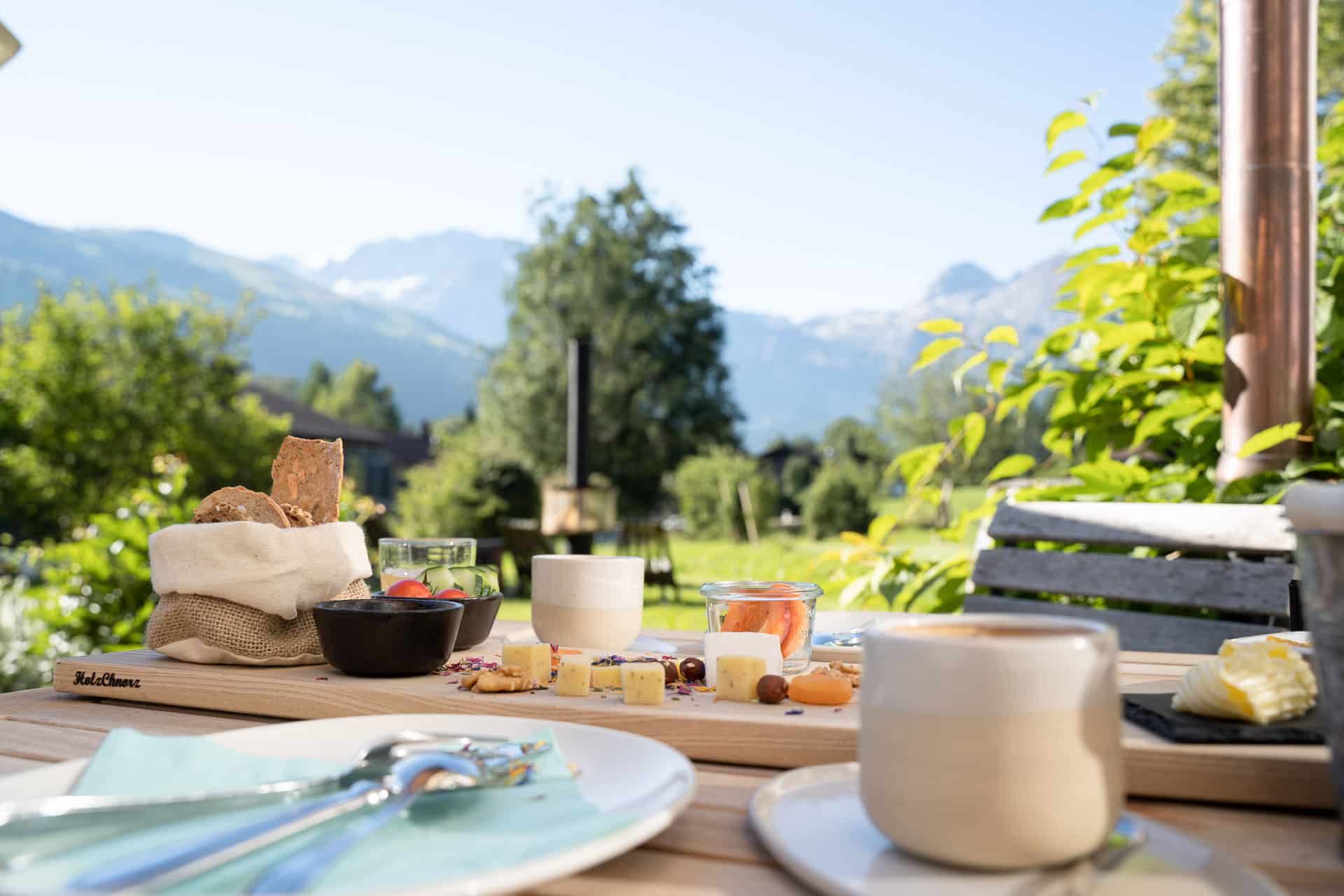 Frühstücksplatte mit Brot und Käse im Garten der Lenk Lodge