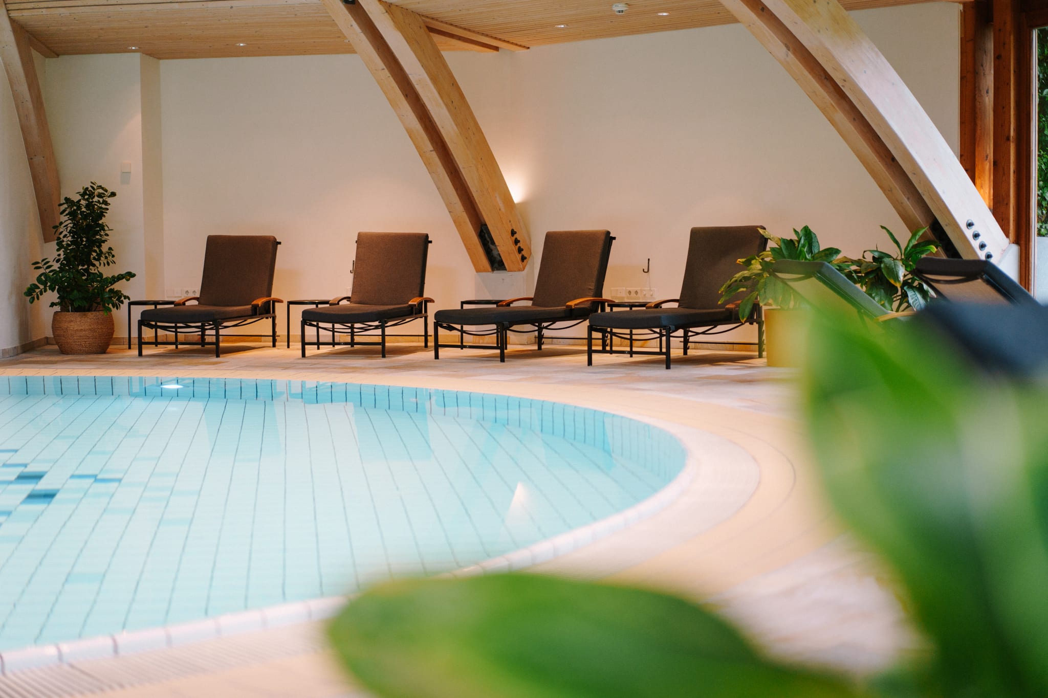 Indoor-Schwimmbad mit Liegen im Daberer Hotel