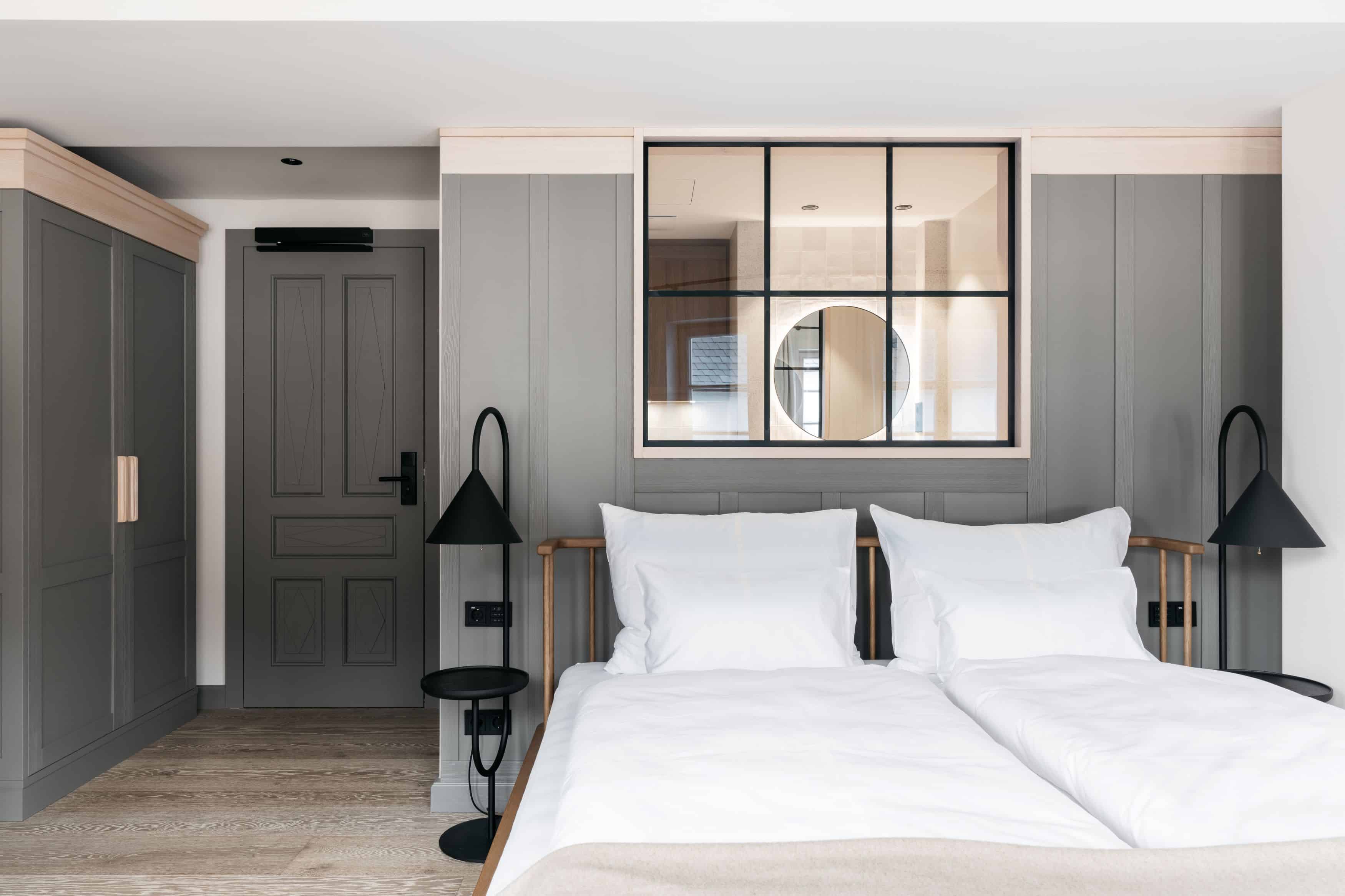 Doppelbett und Badezimmer im Hotelzimmer des Refugium Lunz