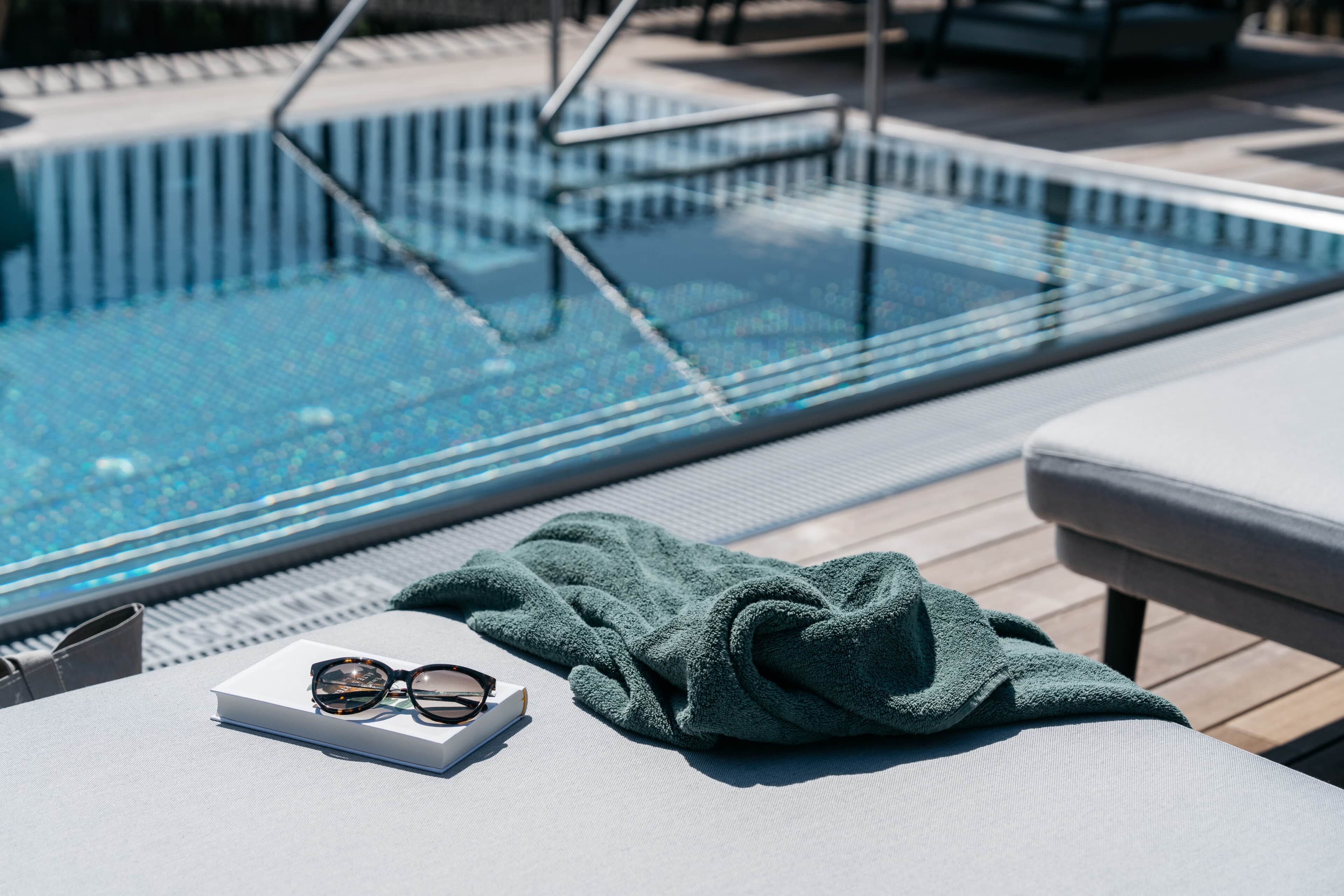 Handtuch, Brille und Buch am Pool im Refugium Lunz