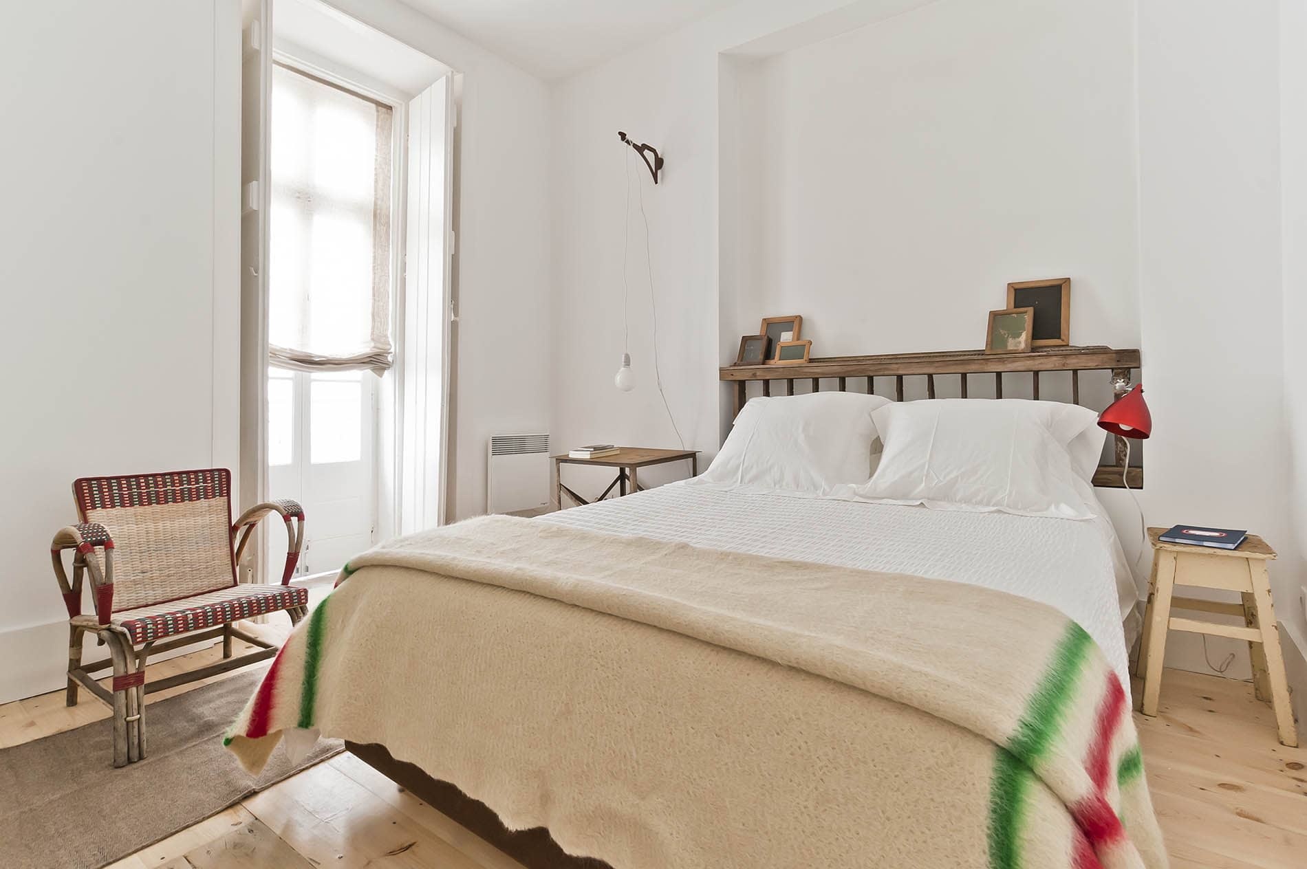 Doppelbett und Stuhl vor Fenster im Baixa House