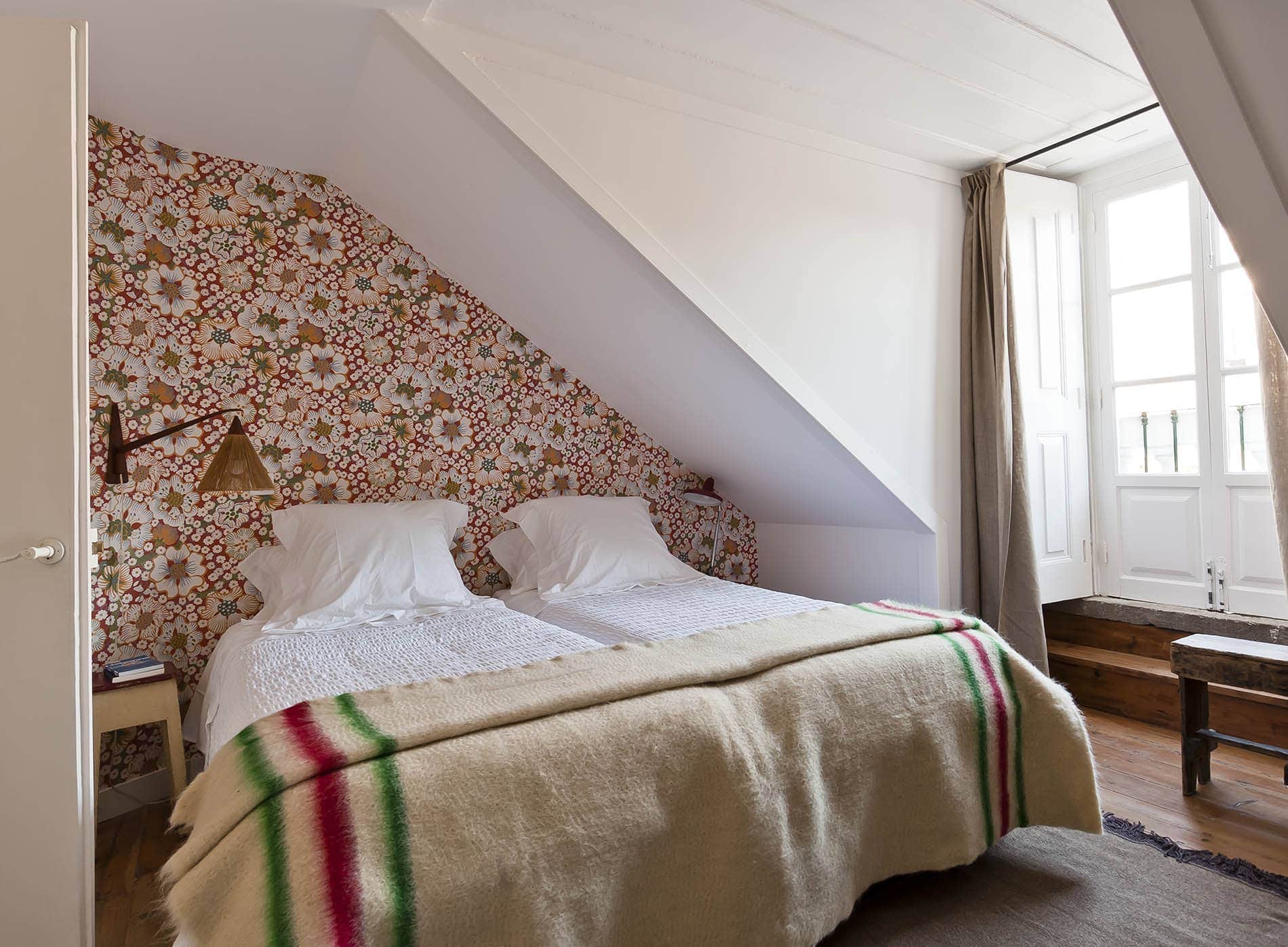 Doppelbett vor Blümchentapete im Baixa House