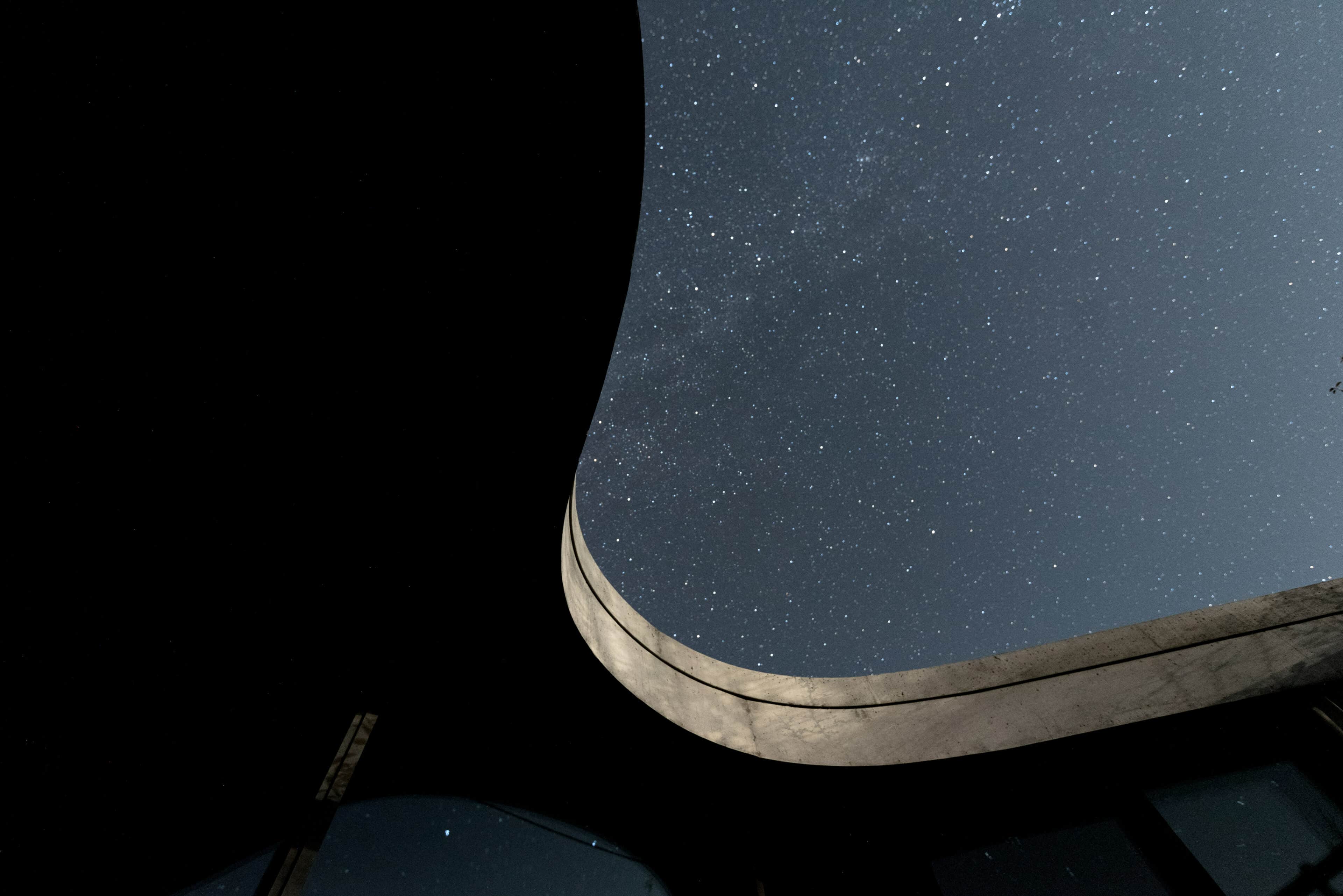 Nachthimmel und geschwungene Dachkante im Gästehaus Freiform