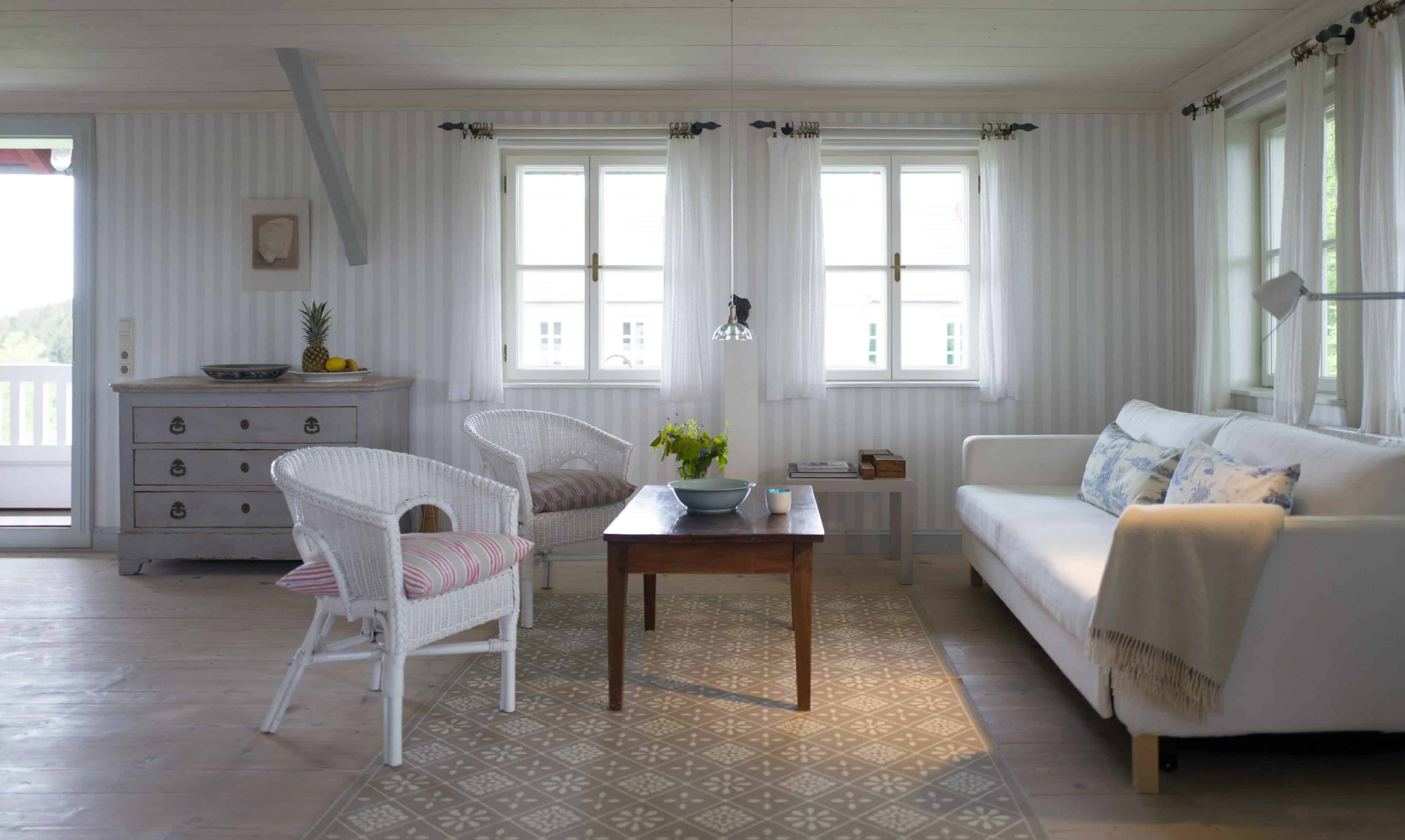 geräumiger Wohnraum mit Sofa und Korbstühlen auf Hof Grillenöd