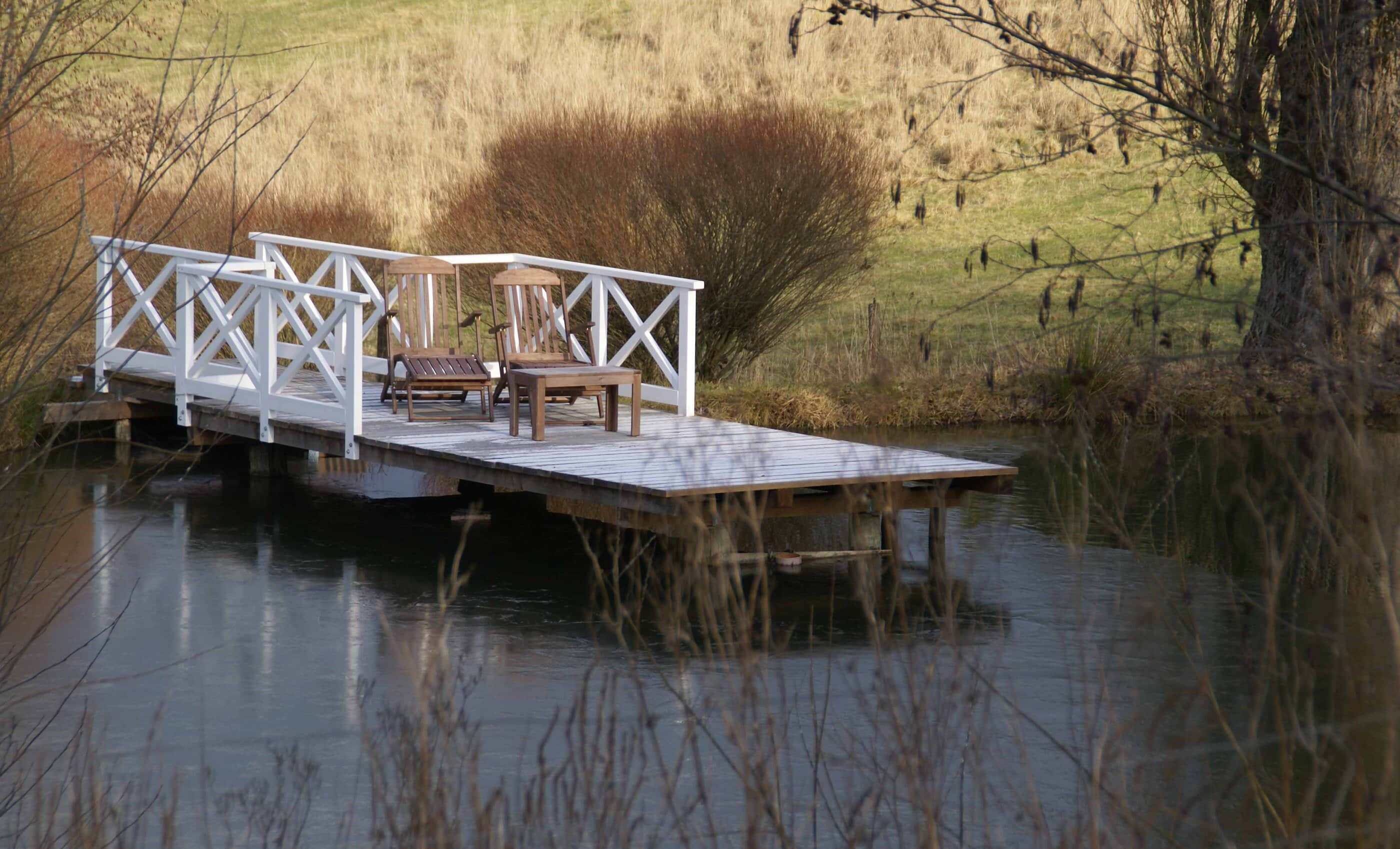 Steg mit Holzstühlen am See
