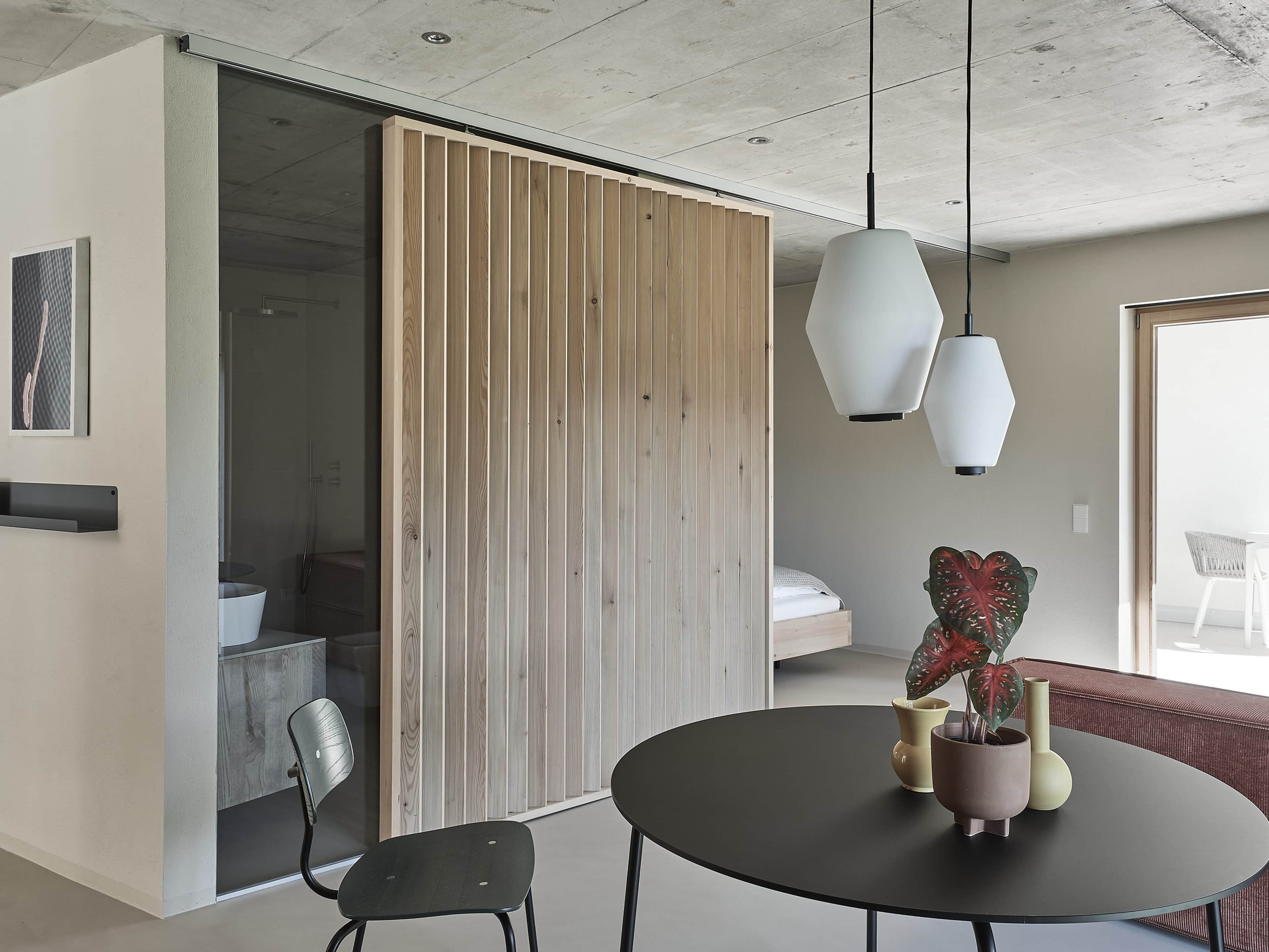 Zimmer mit Tisch und Badezimmer im Refugium Rochus