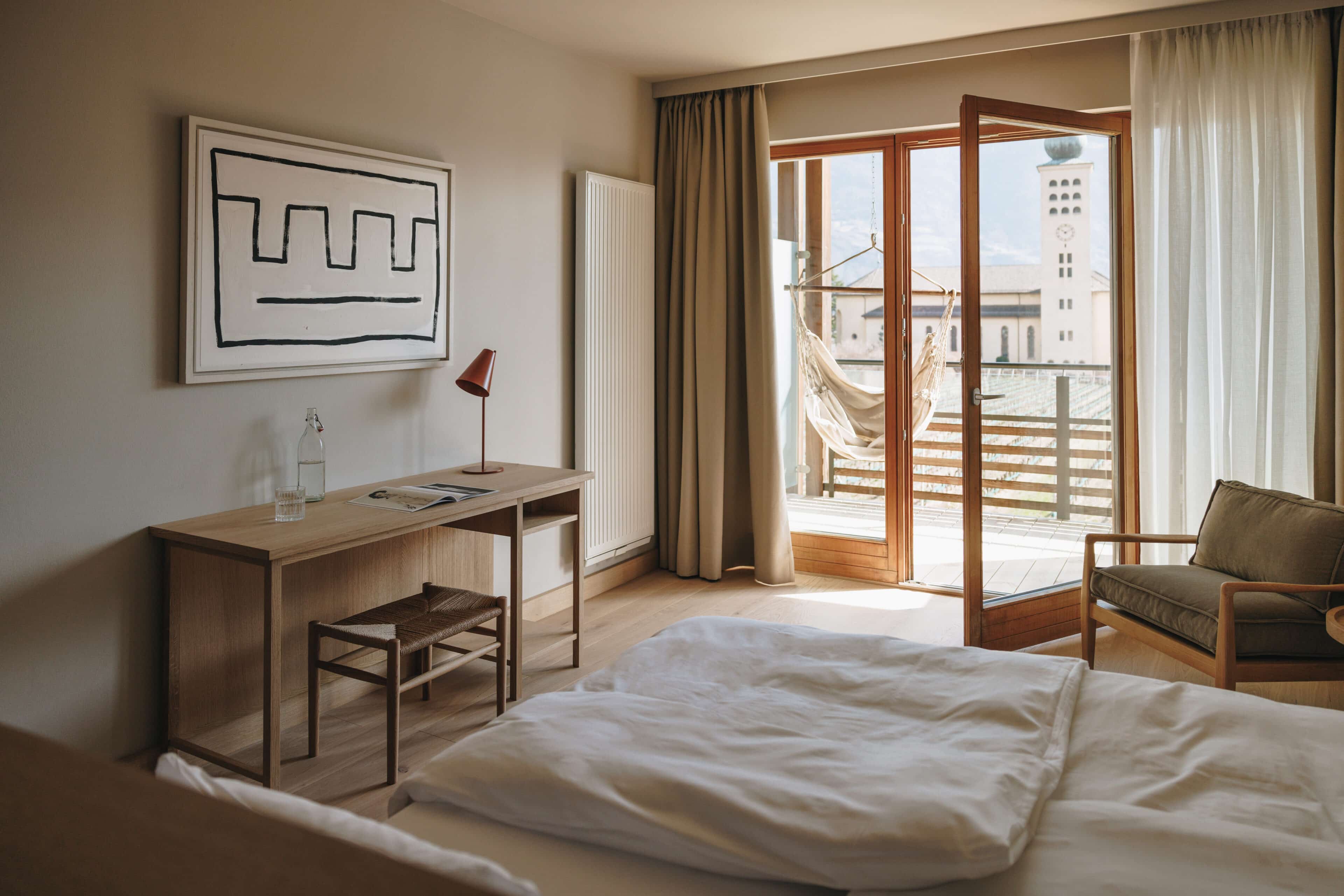 Doppelzimmer mimt Schreibtisch, Balkon und Hängesessel im Hotel Schwarzschmied