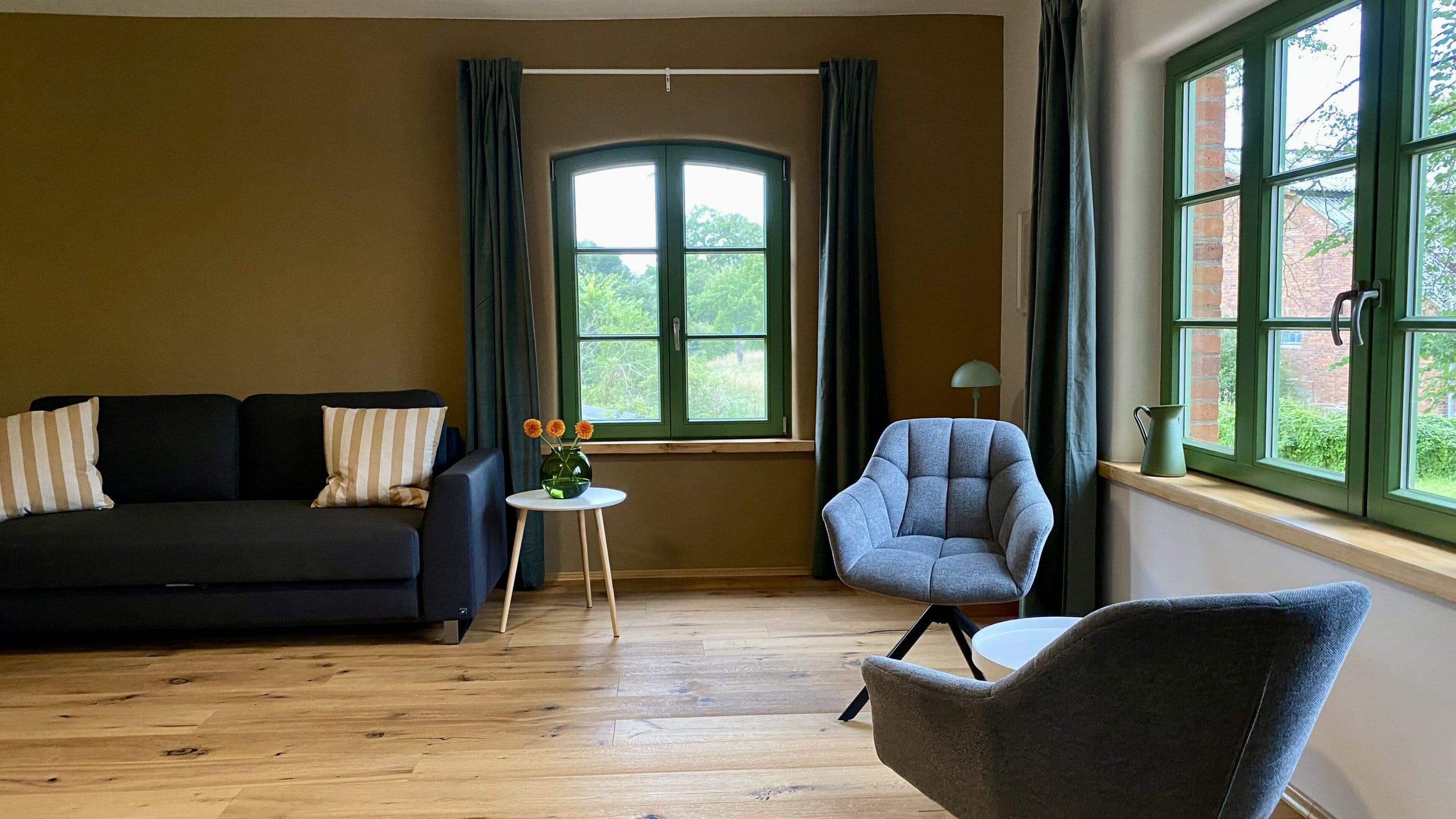 Wohnzimmer mit Gitterfenster, Sessel und Sofa, Ulmenhof