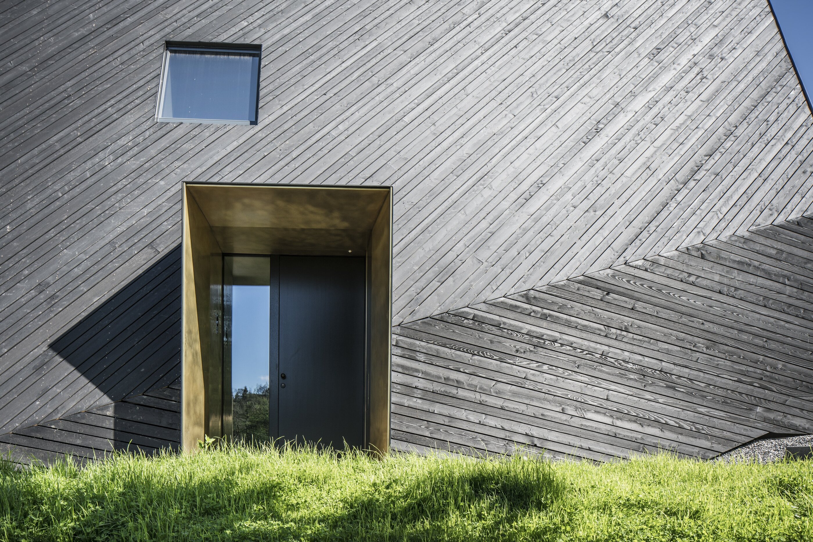 Eingangsbereich mit Hoolzfassade im Sonnenschein, VA House