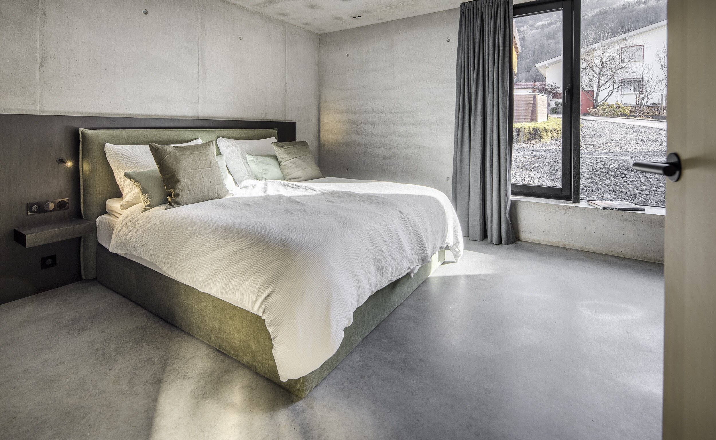 Schlafzimmer mit Doppelbett und großem Fenster