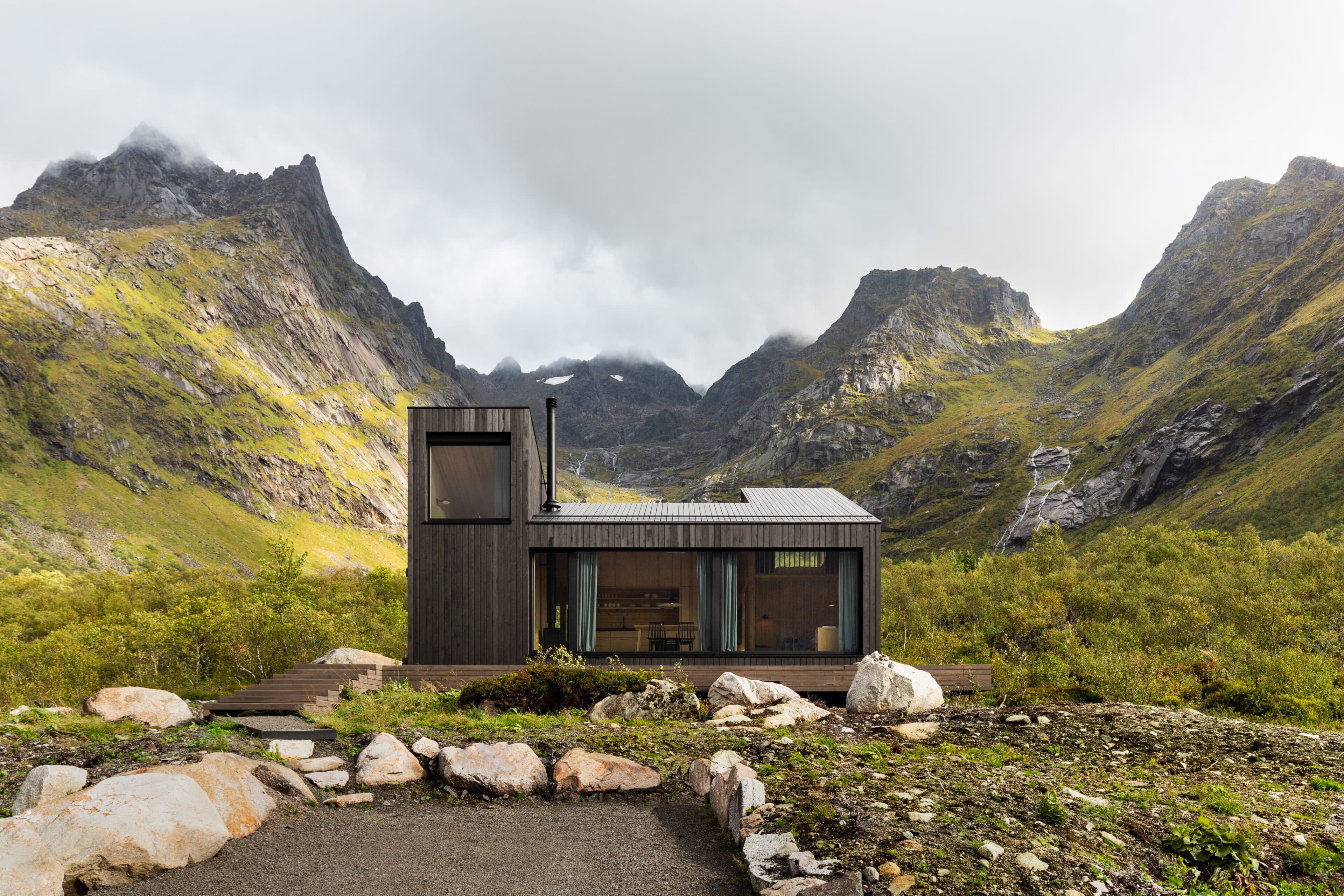 Holzhaus vor zerklüftetem Bergpanorama