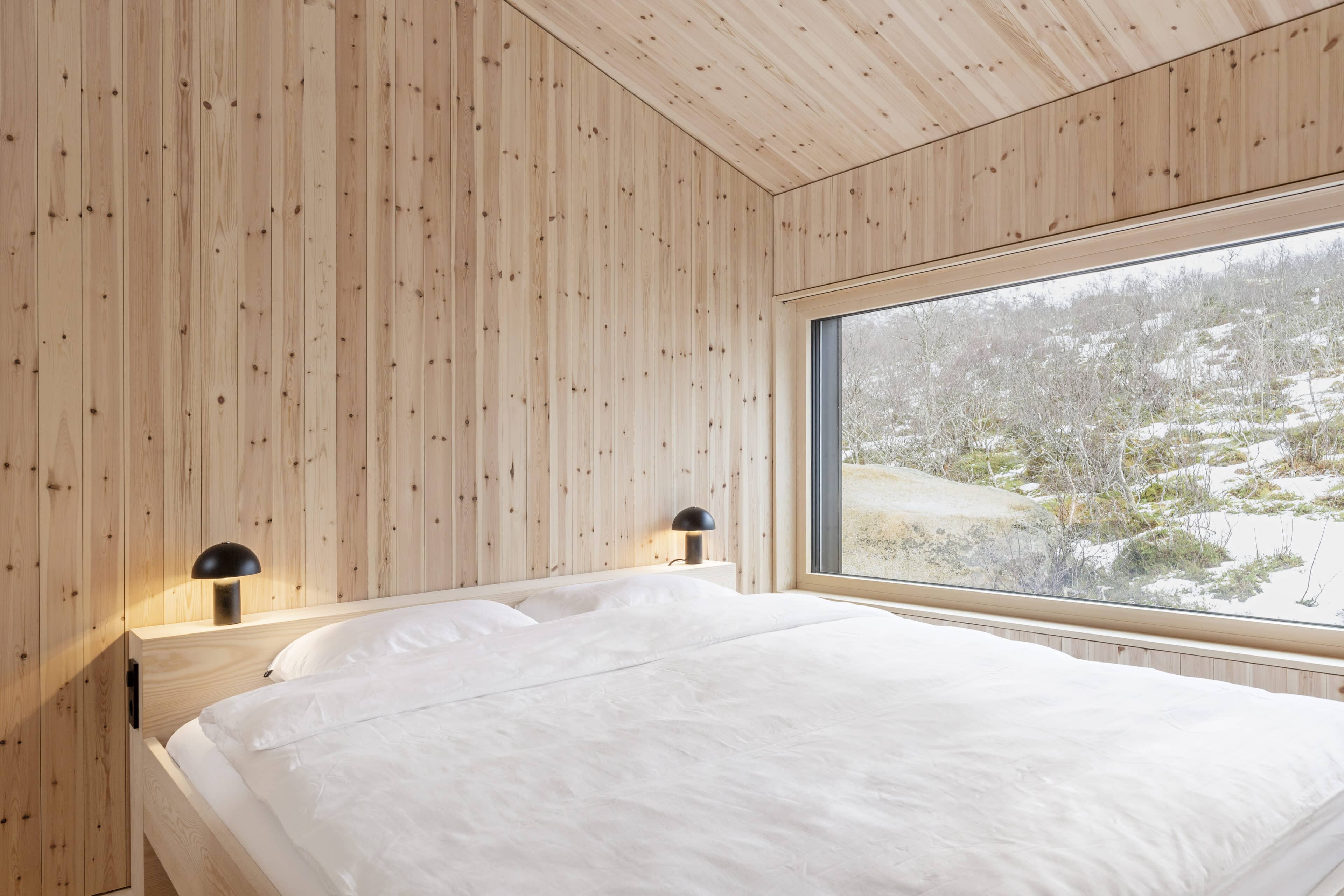 Doppelbett in Schlafzimmer mit Holzpaneelen