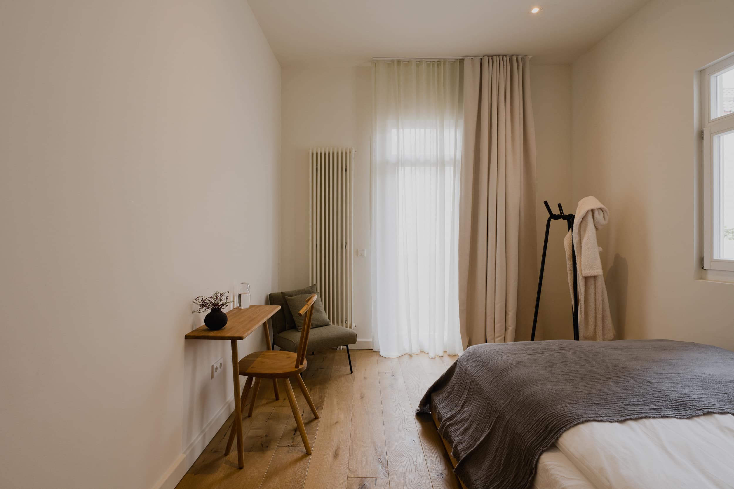 Bett und Schreibtisch im Doppelzimmer mit Blick zum Fenster