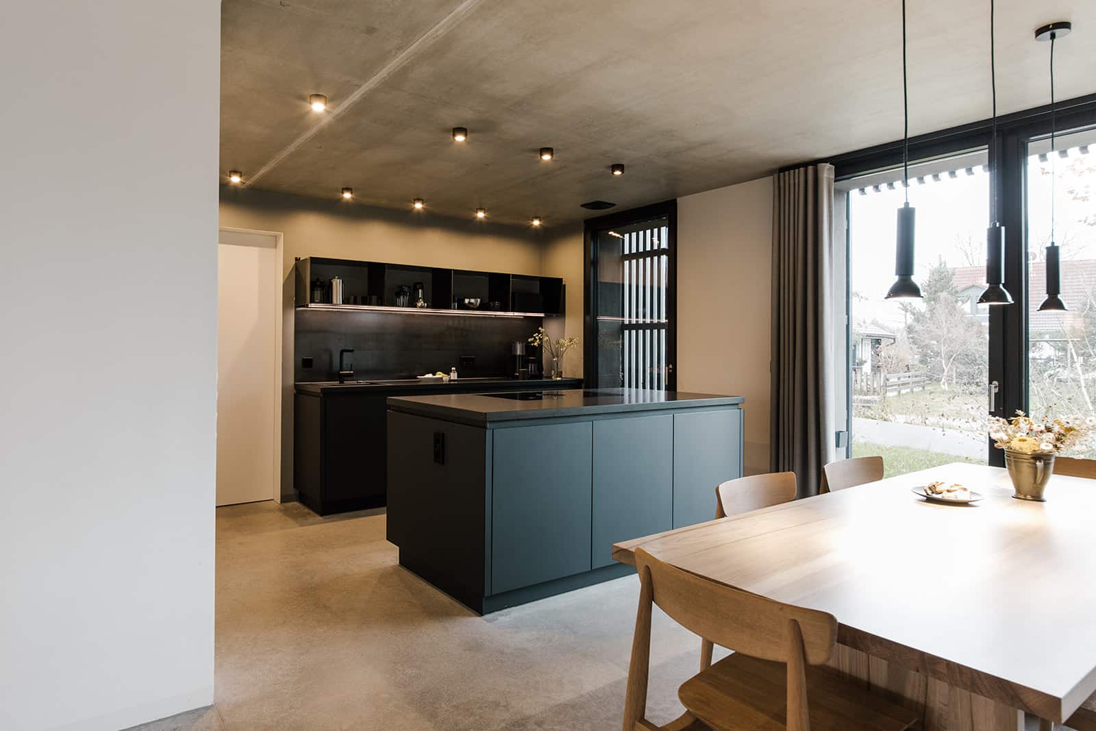 Dunkle Küchenzeile und Holzesstisch