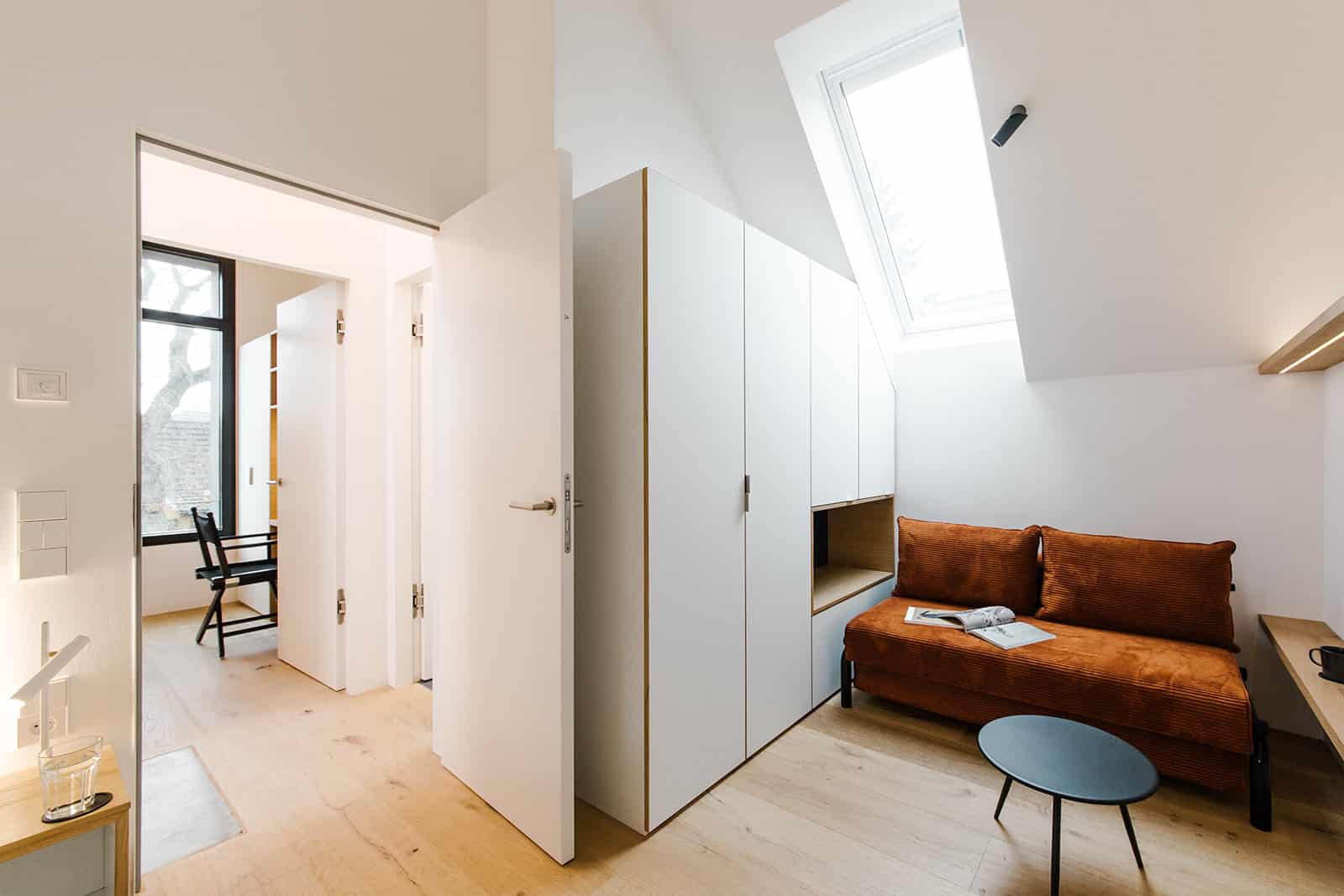 Braunes Sofa vor Schrank und offene Tür