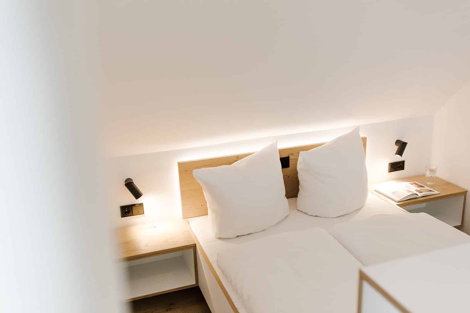 Blick auf Doppelbett mit Beleuchtung