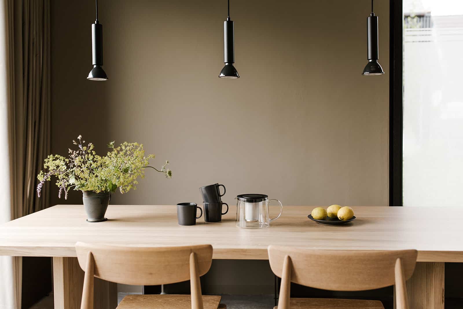 Esstisch mit Teekanne, Blumen und Obstschale