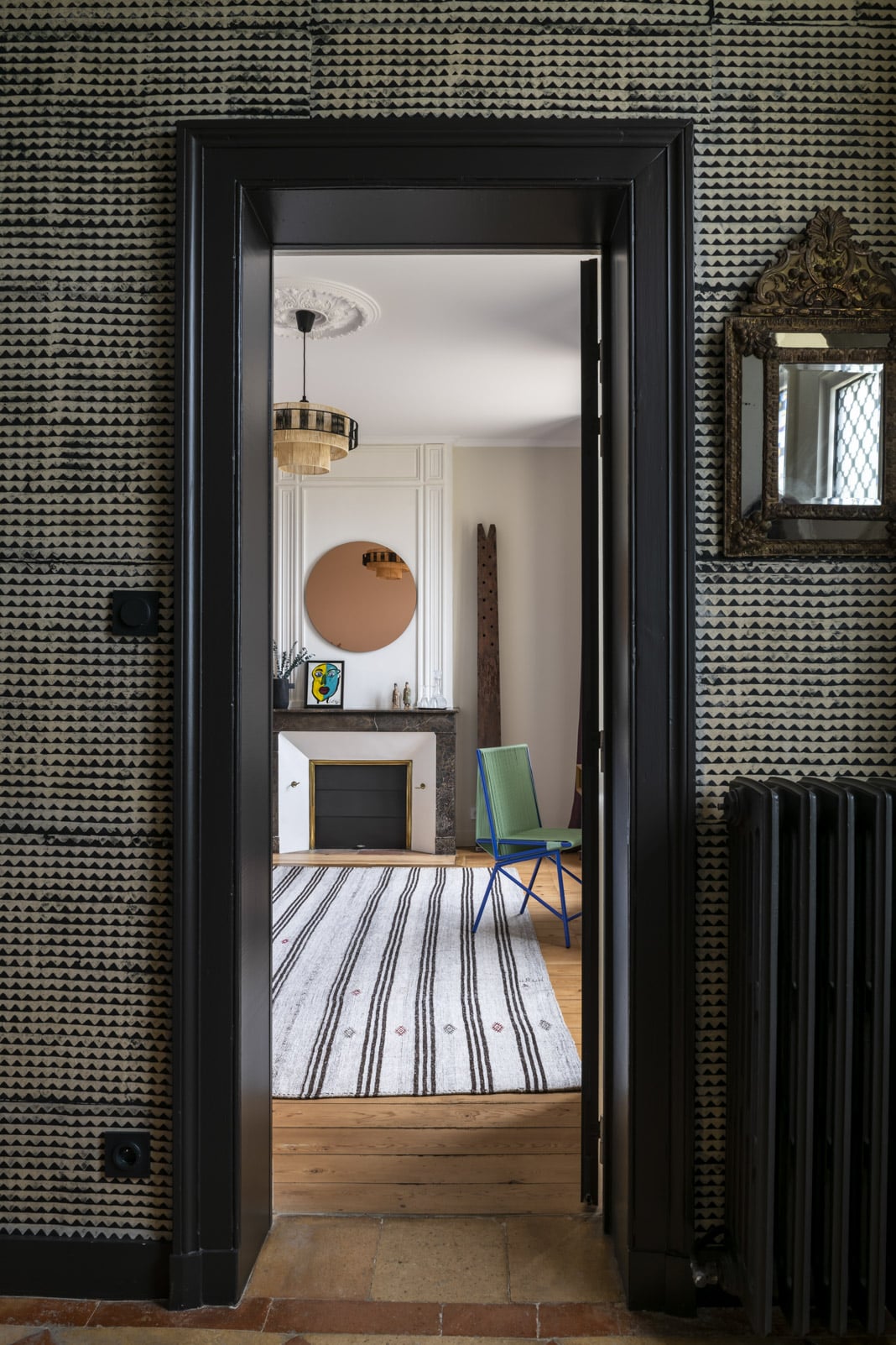 Blick durch einen Türrahmen ins Schlafzimmer mit Kamin