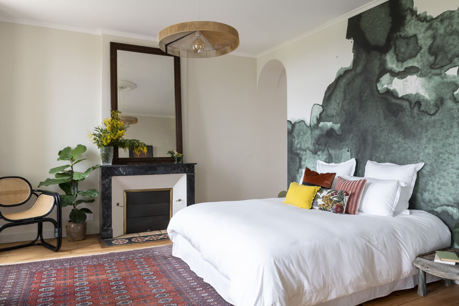 Schlafzimmer mit Doppelbett, Wandkunst und Kamin