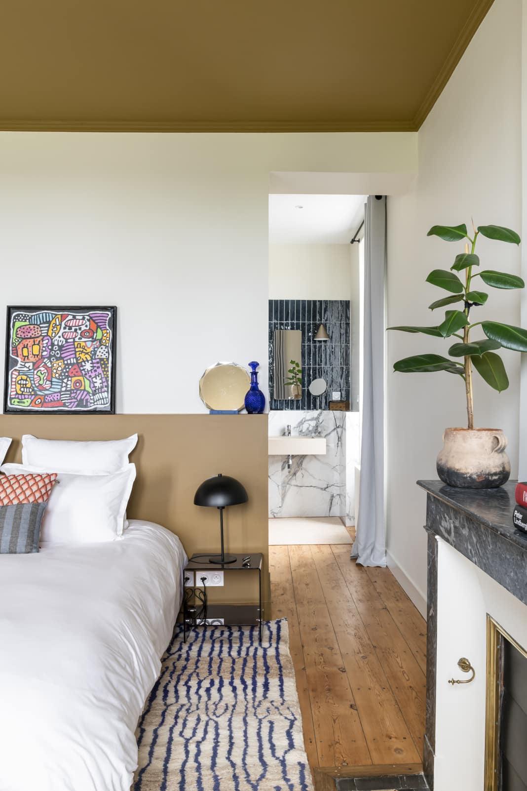 Schlafzimmer mit Bett und Blick ins Badezimmer