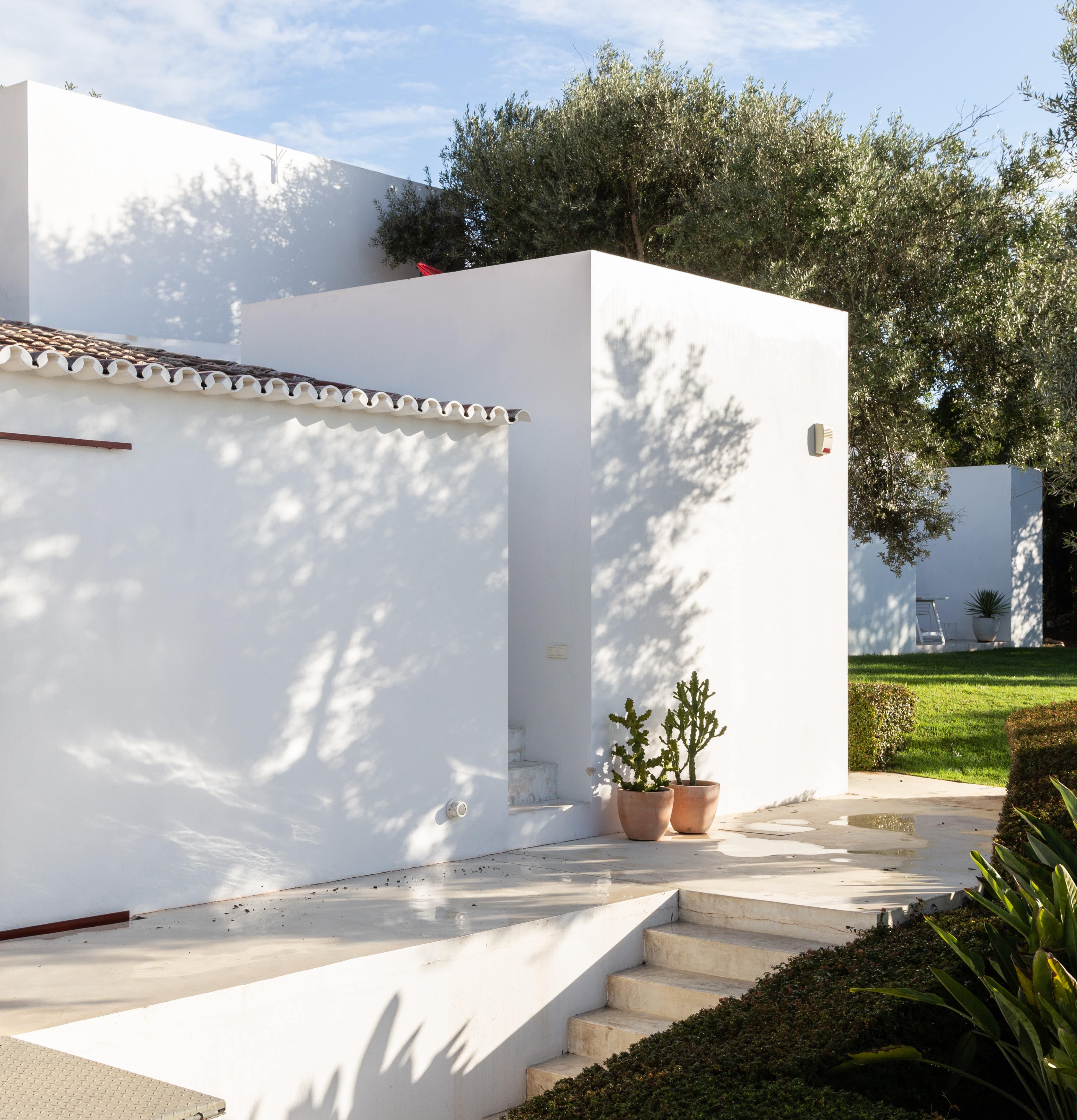 Sonnenstrahlen fallen auf eine Ecke des weißen Bungalows