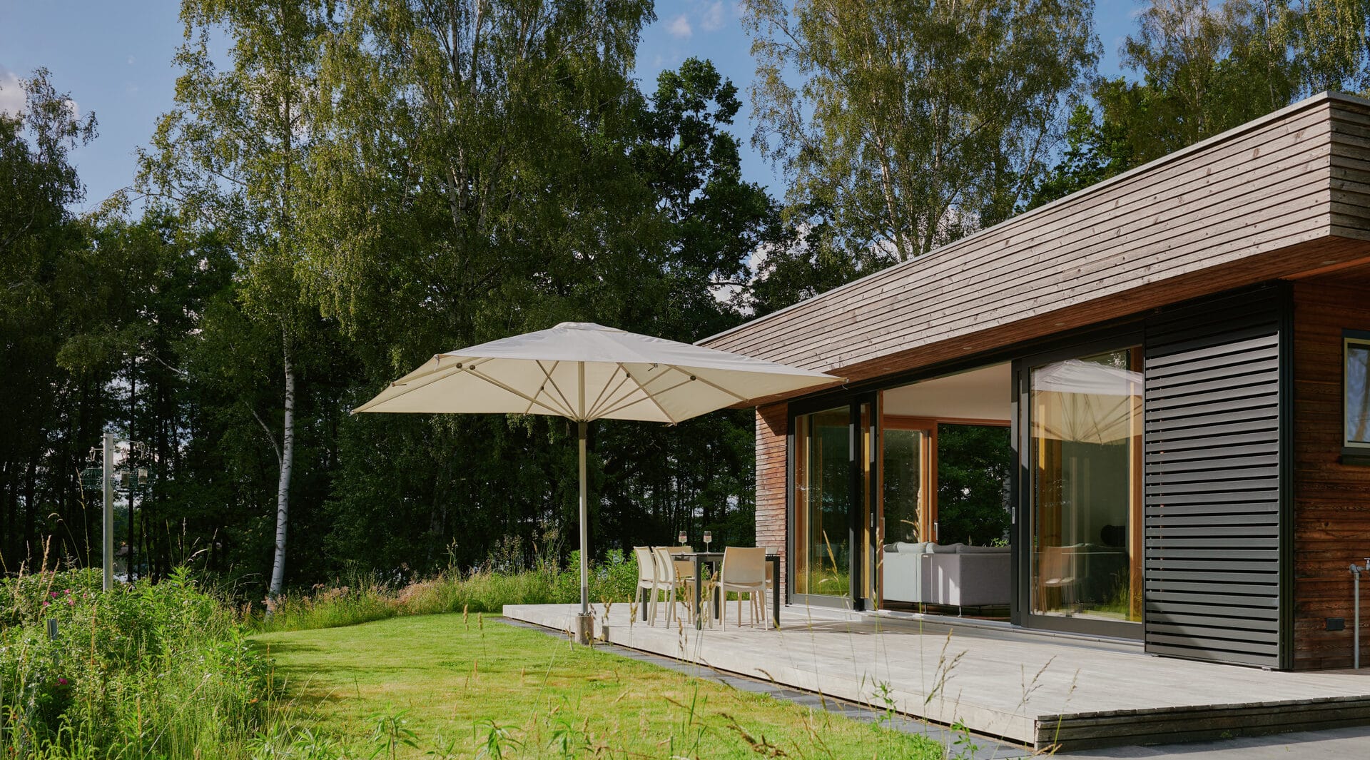 Terrasse mit Sonnenschirm und Garten