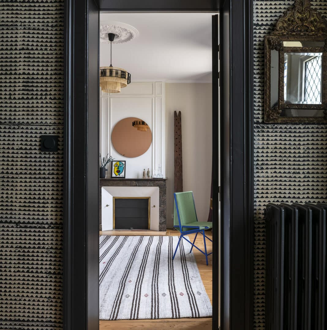 Blick durch einen Türrahmen ins Schlafzimmer mit Kamin