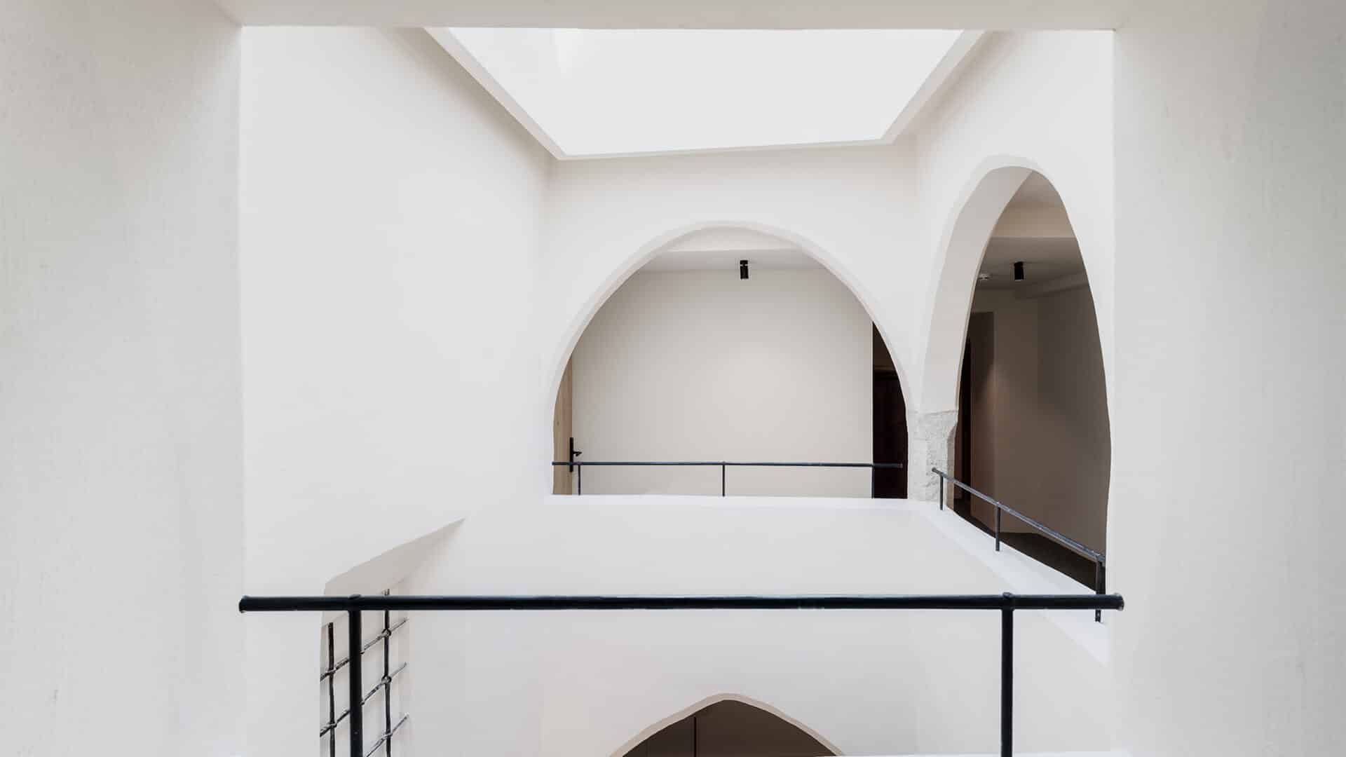Treppenhaus mit weißen Bögen im Adler Historic Guesthouse