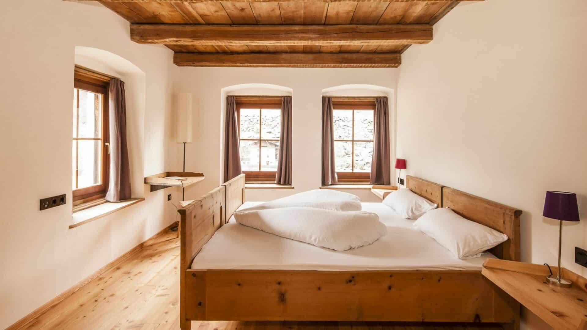 Schlafzimmer mit Bett und Decke aus Holz
