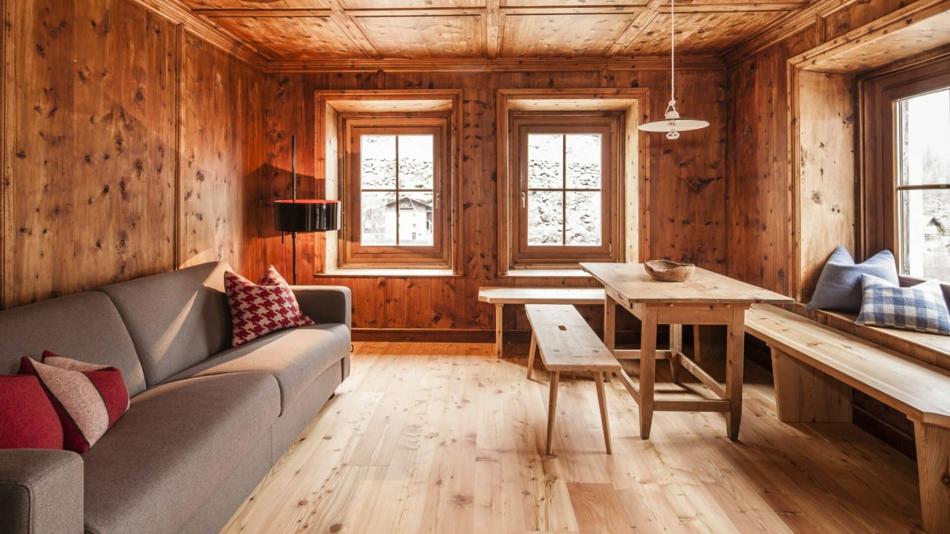 gemütliche Stube aus Holz mit Sofa und Tisch