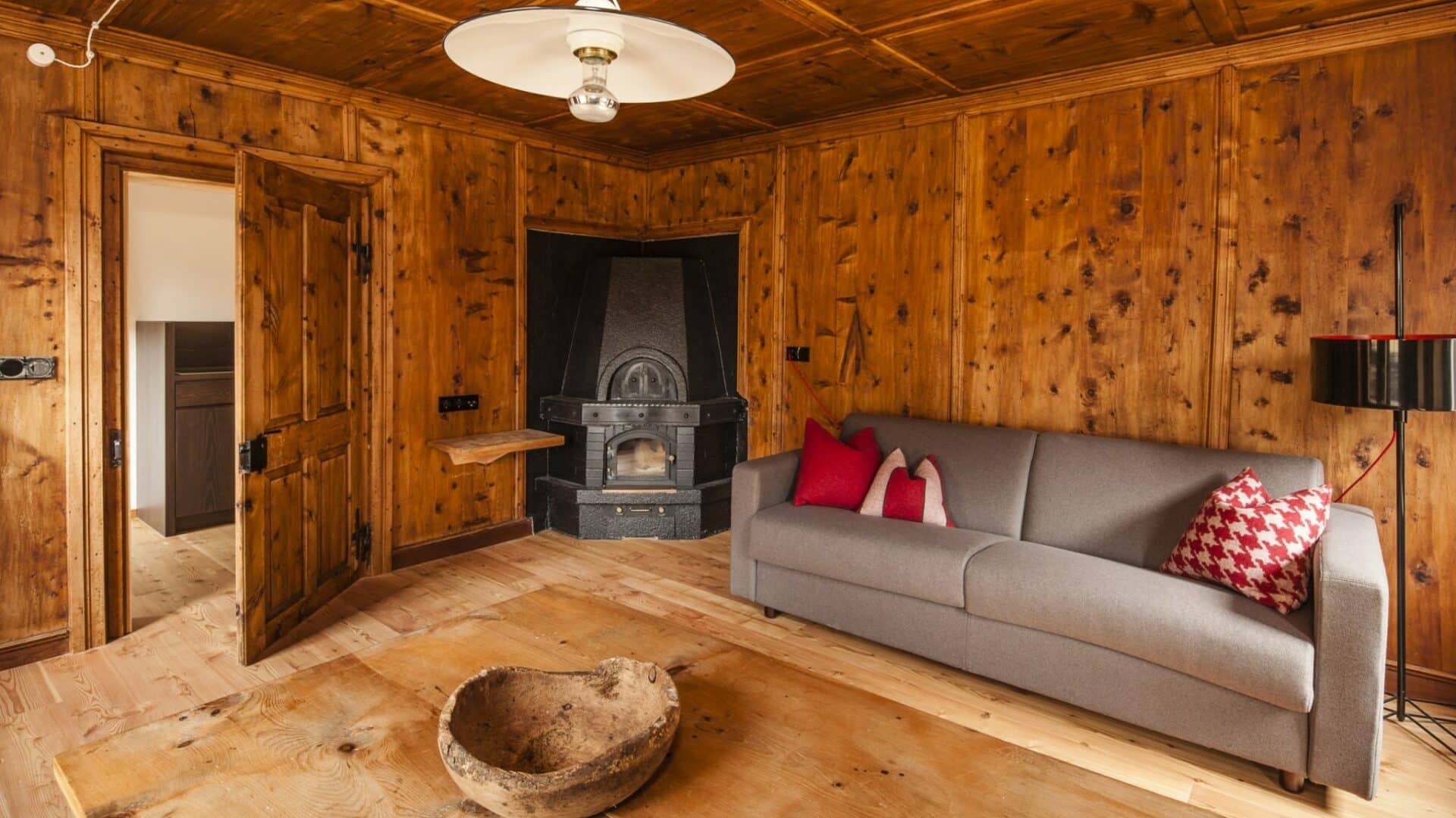 Stube aus Holz mit Sofa und Kamin
