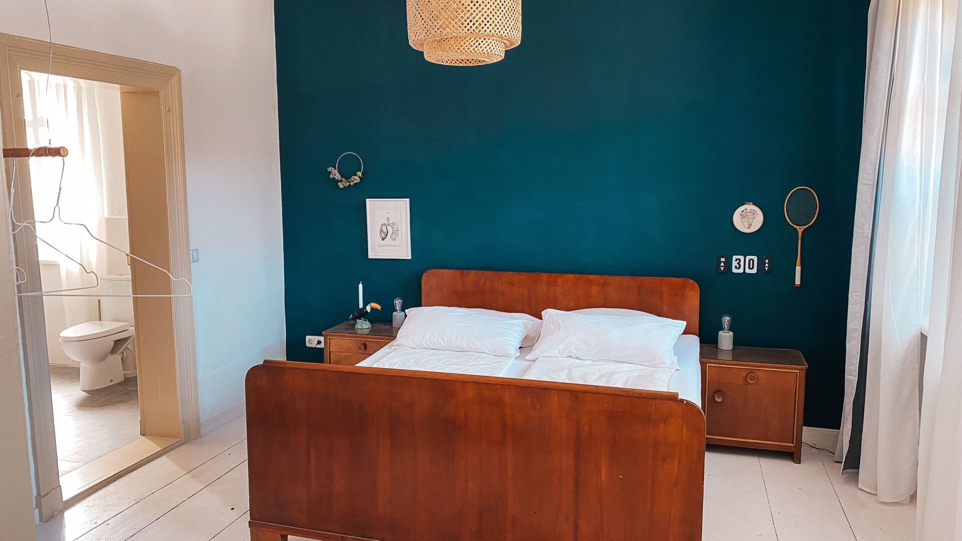 Vintage Holz-Doppelbett vor blauer Wand im Alten Dorfhaus