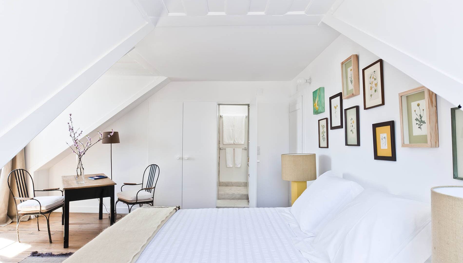 Doppelzimmer unterm Dach mit Bett und Tisch im Baixa House