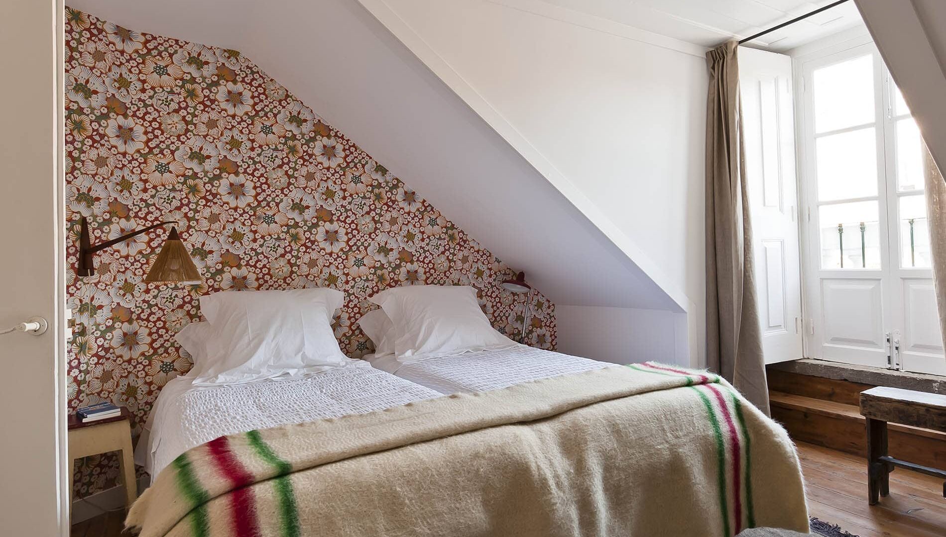 Doppelbett vor Blümchentapete im Baixa House